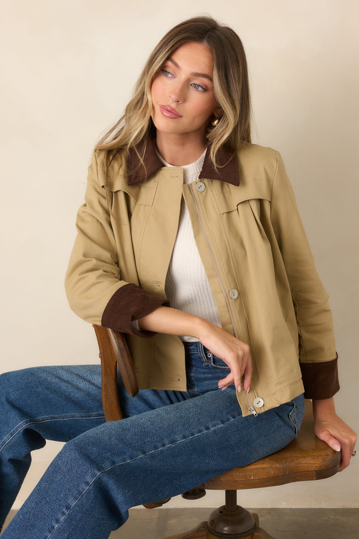 Brown corduroy collar contrasts with the smooth khaki body and structured front of the jacket.