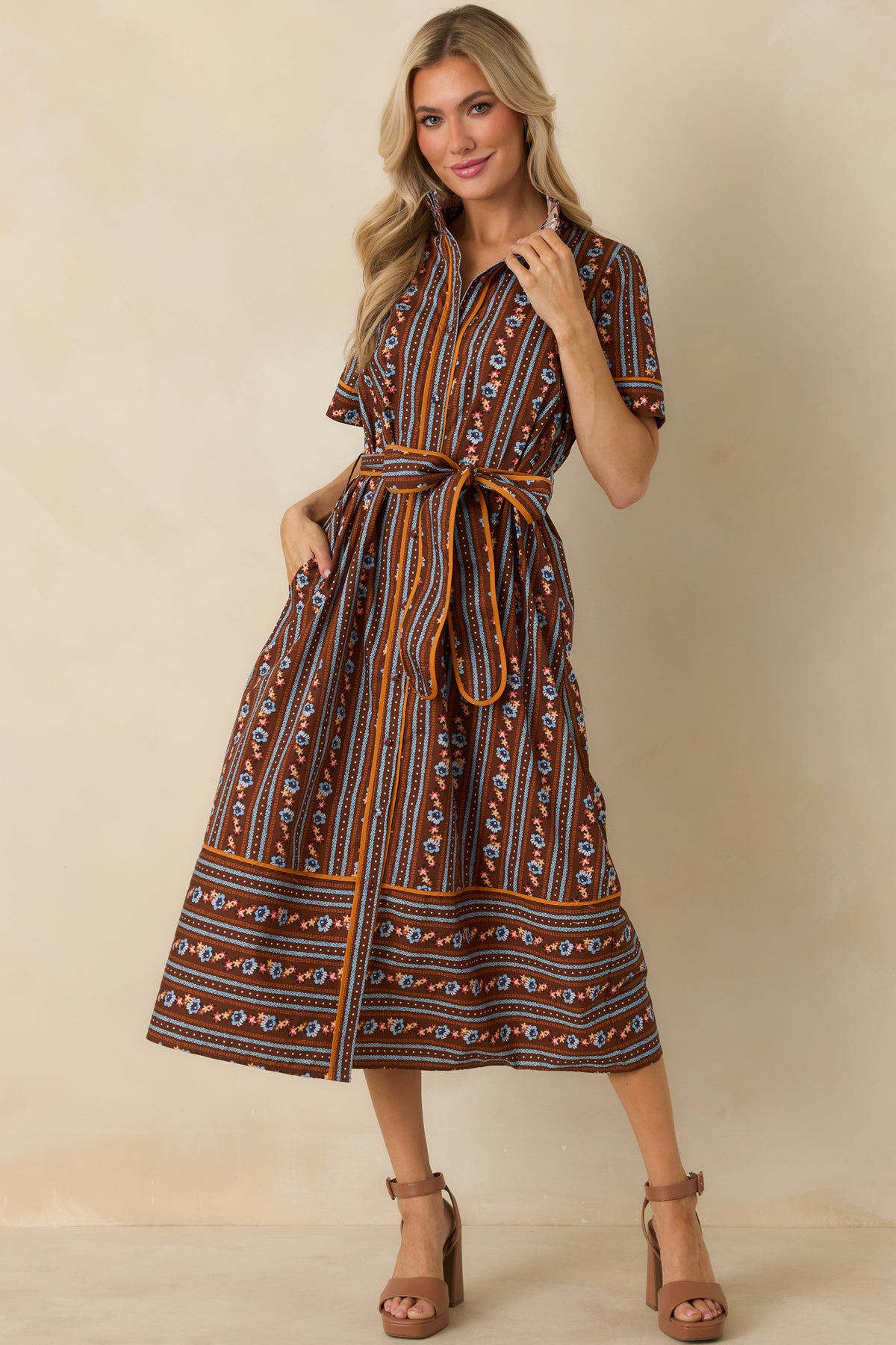 Brown cotton A-line dress featuring alternating floral and patterned stripes in blue, orange, ivory, and rust.