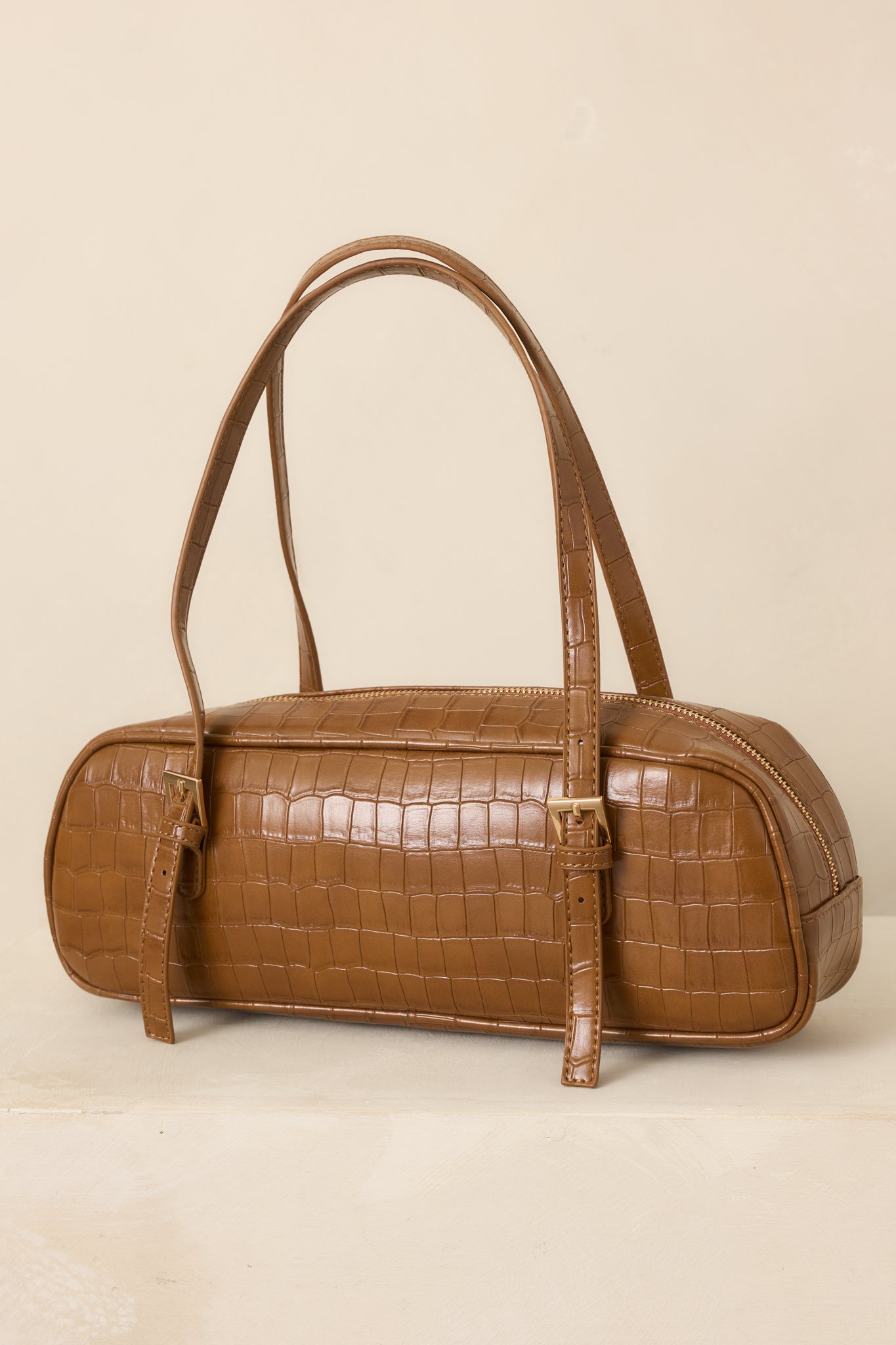 Close-up of the brown croc-embossed faux leather texture and structured top handle detailing.