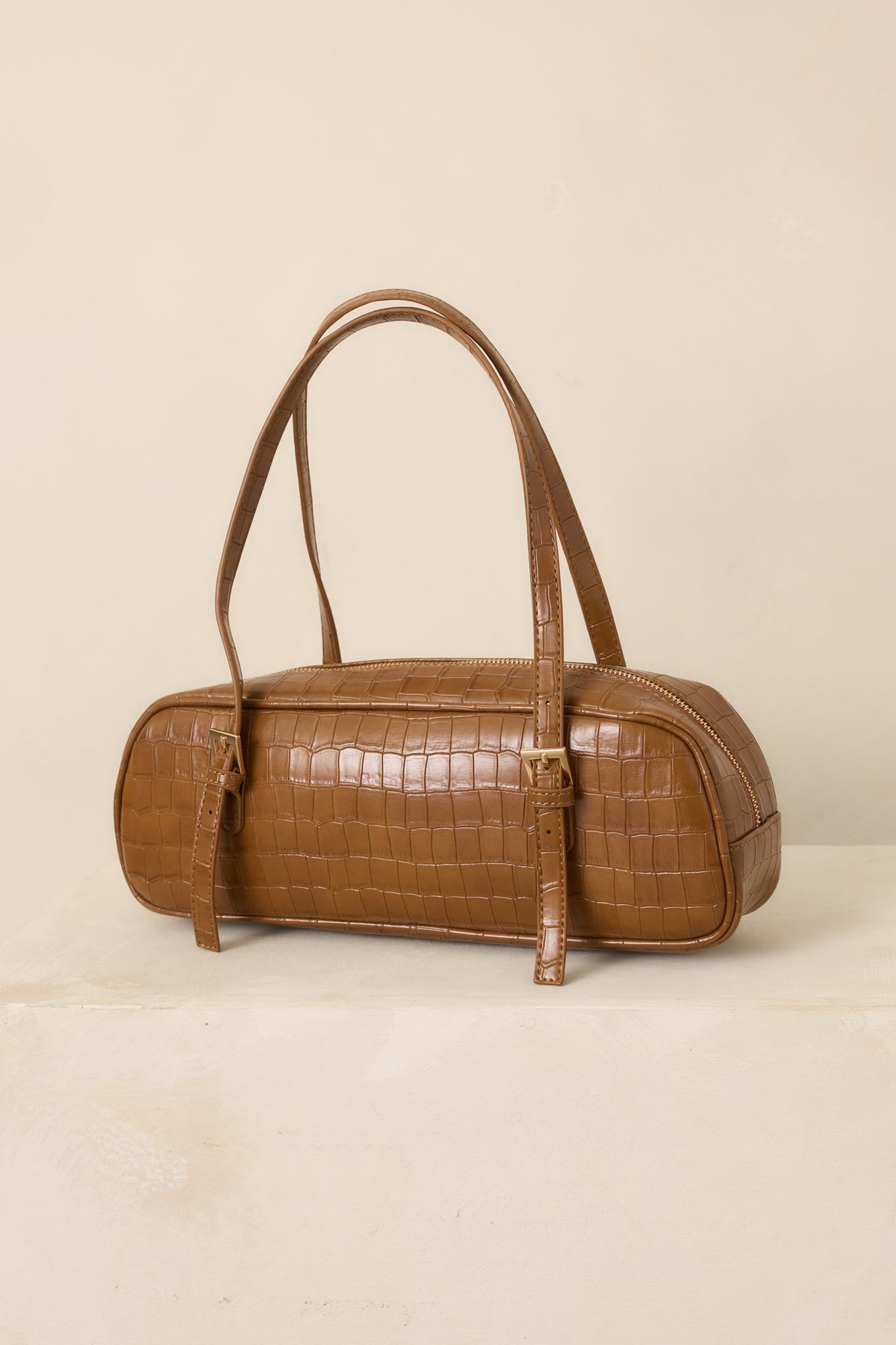 Sophisticated brown handbag featuring a textured croc-embossed exterior, sturdy top handles, elongated silhouette, and secure zip closure.