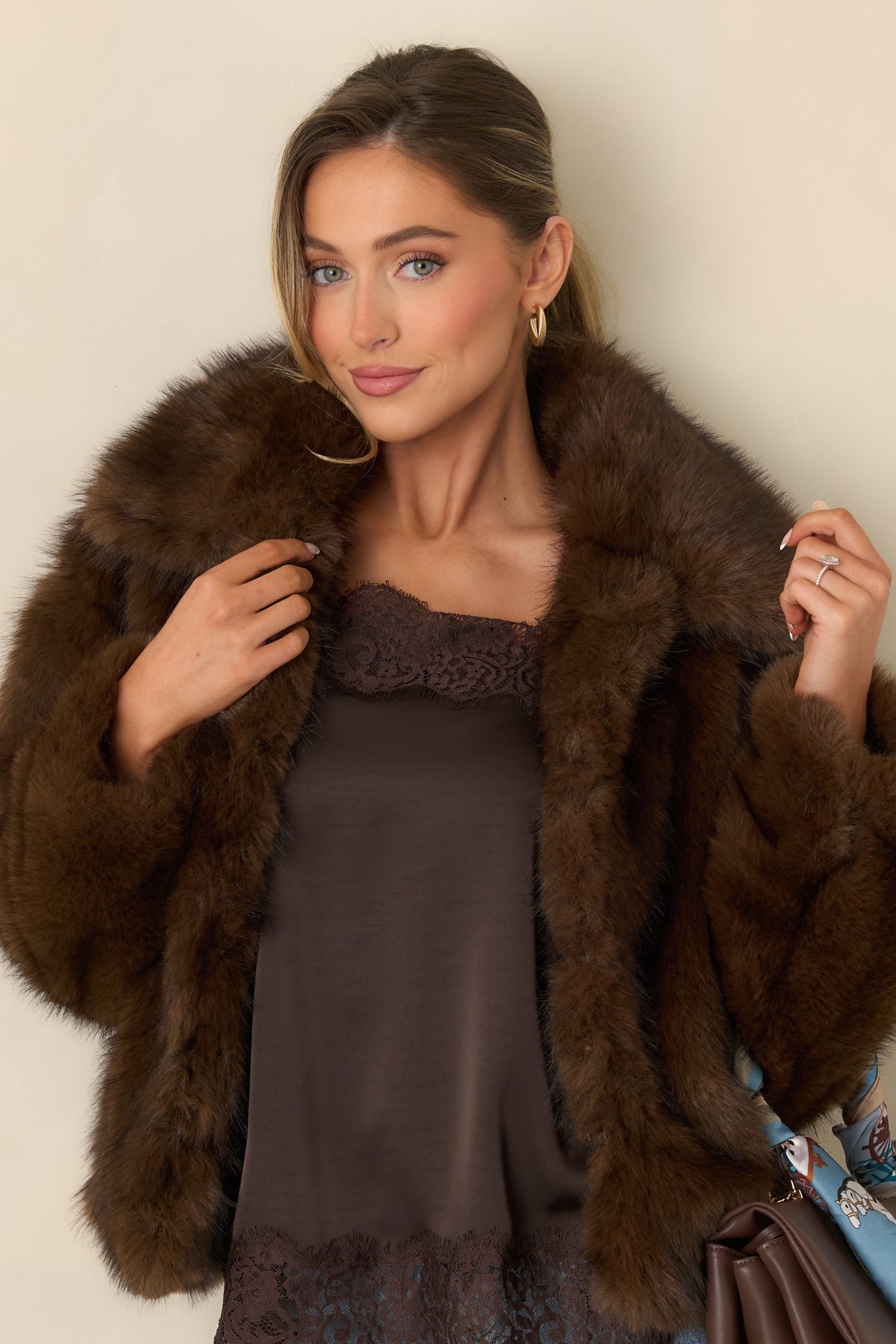 Three front hook closures secure the plush brown faux fur jacket.
