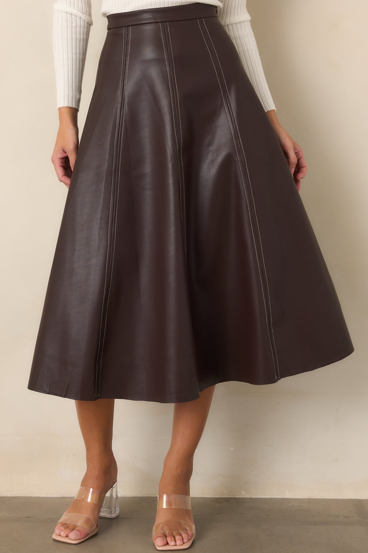 Brown faux leather A-line skirt with polished contrast stitching and a clean flared silhouette.