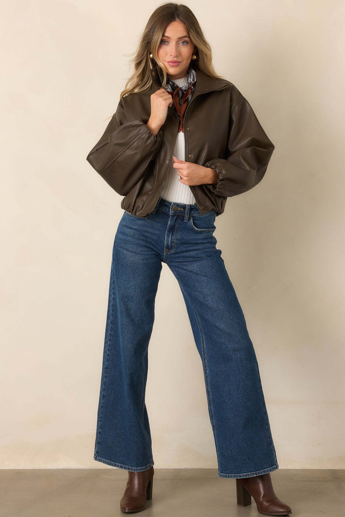 Rich brown faux leather jacket with a high stand collar, balloon sleeves, gathered hem, and side pockets.
