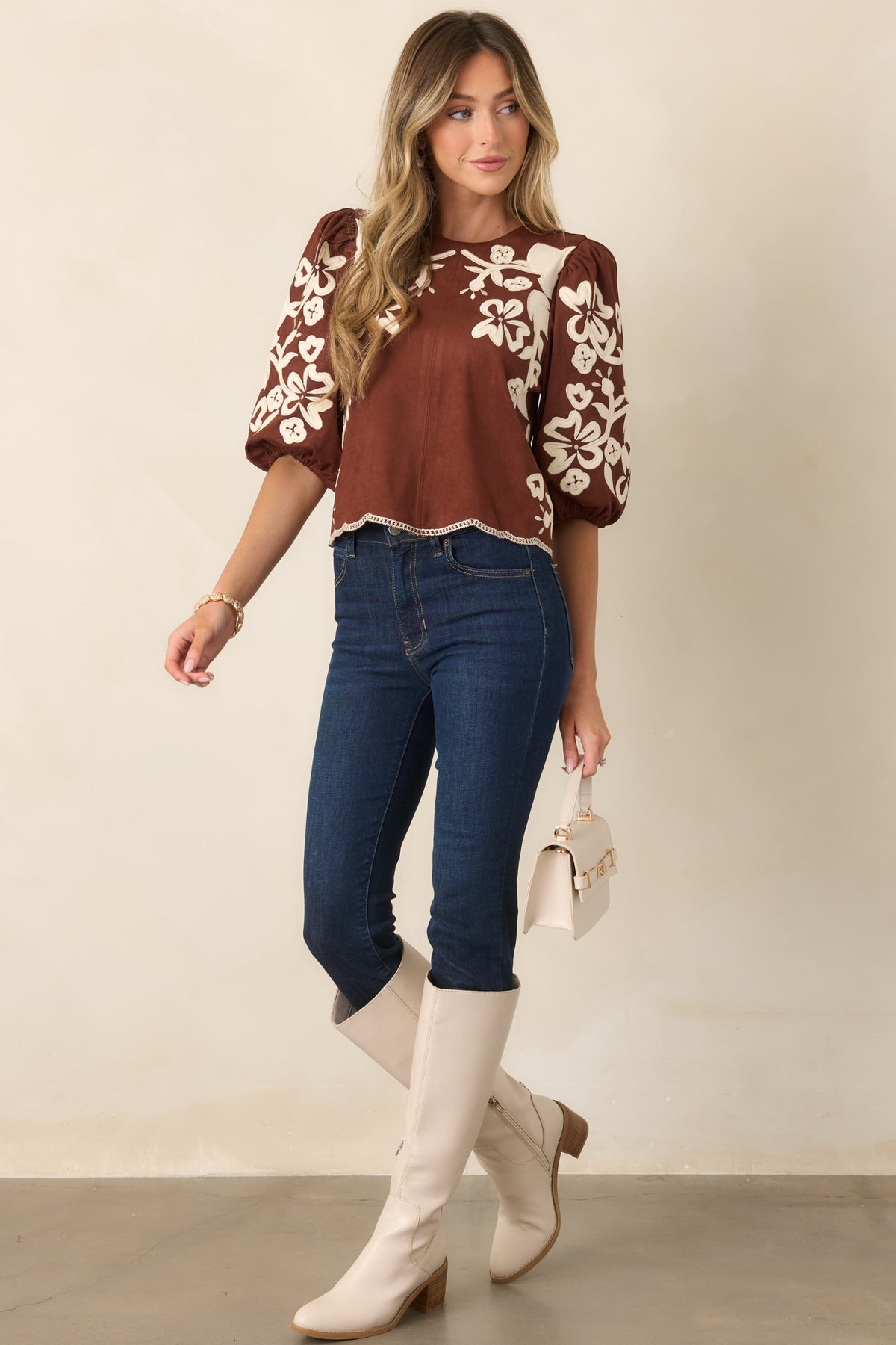 Warm brown faux suede top showcasing ivory floral appliqués and voluminous elbow-length sleeves.