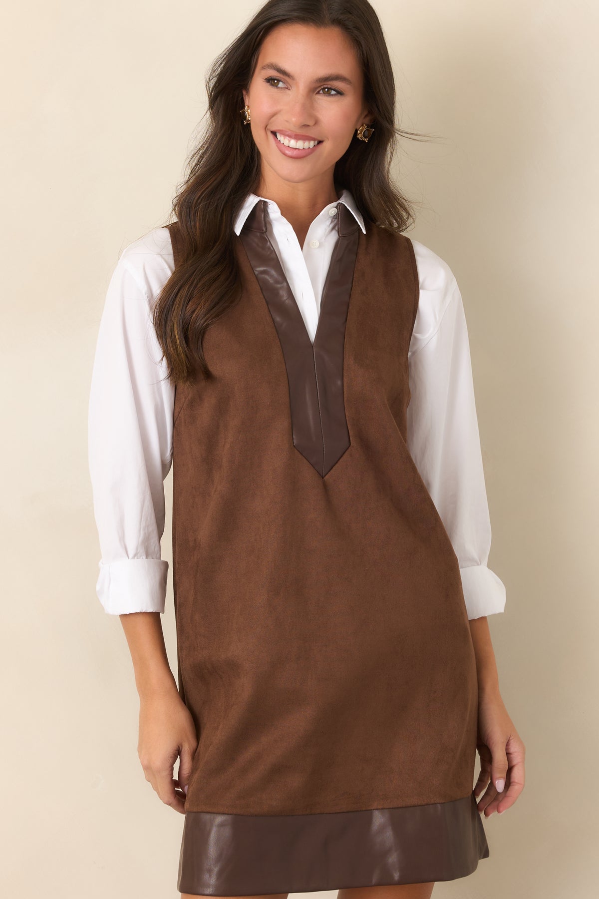 Rich brown faux suede mini dress with smooth leather-look trim framing the hem.