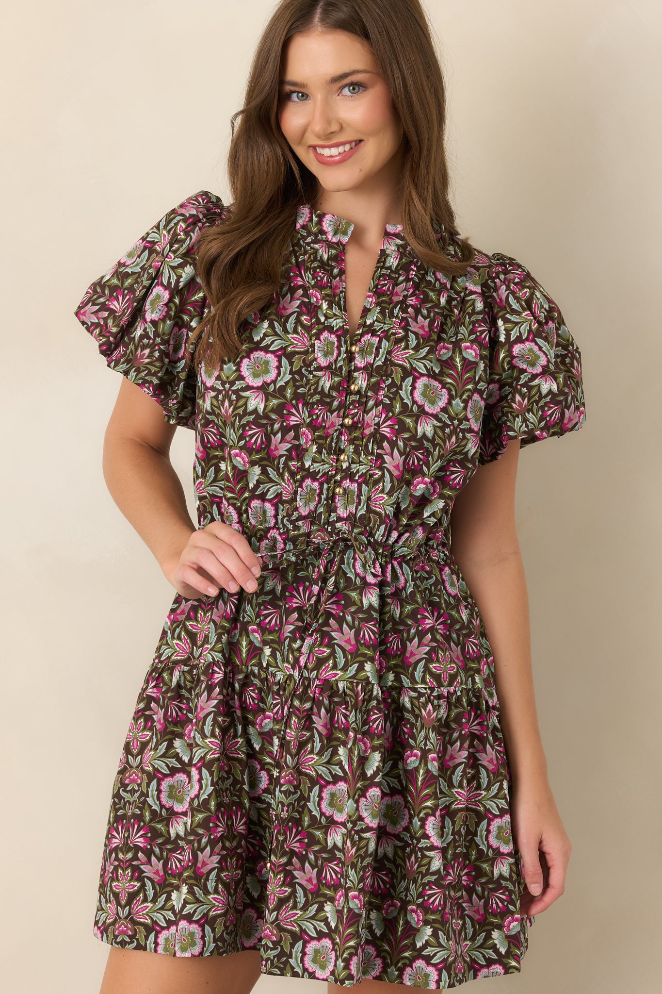 Adjustable drawstring waist gathers the brown floral dress above its softly tiered mini skirt.