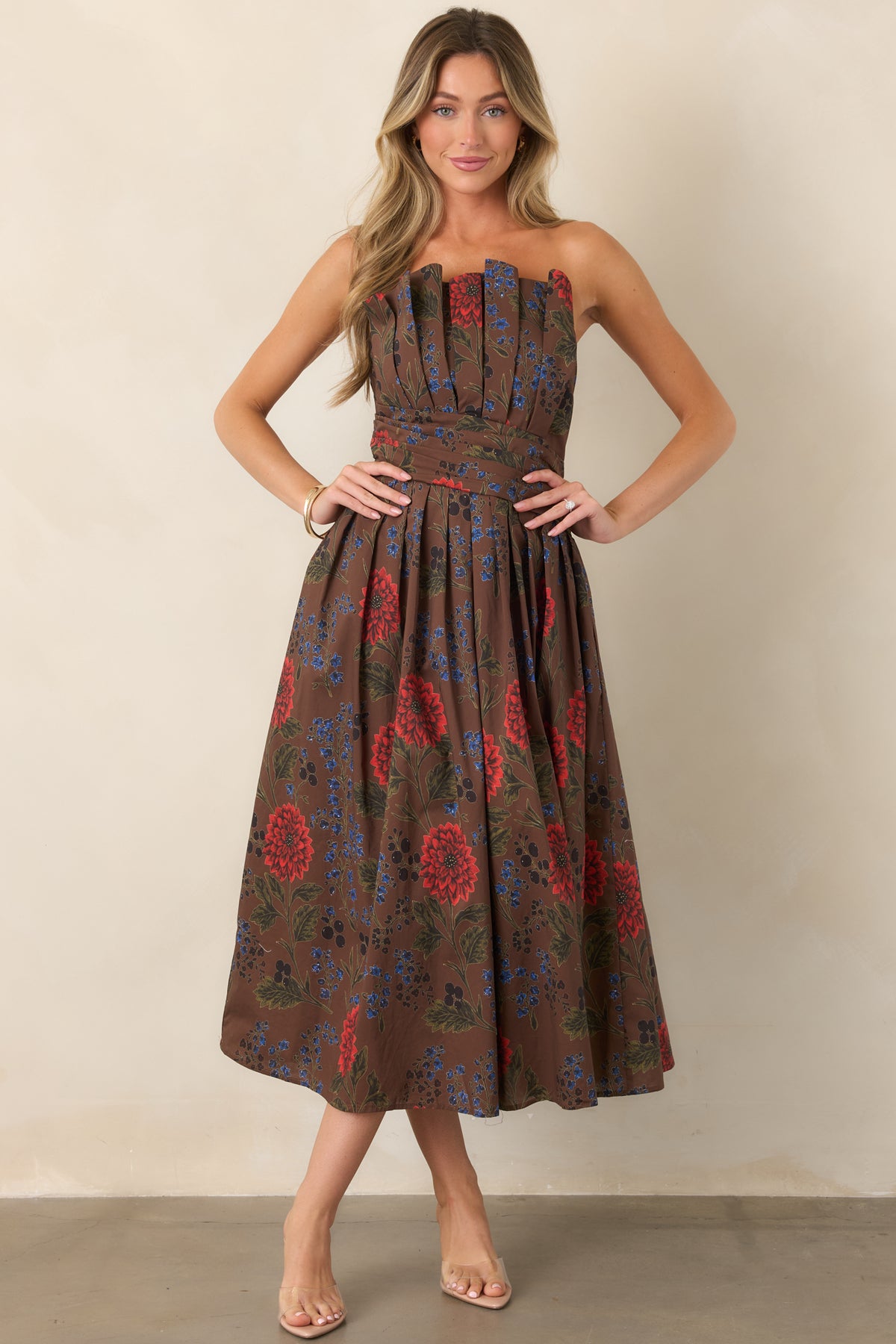 Front view of a brown floral midi dress featuring a strapless pleated bodice and defined waistband.
