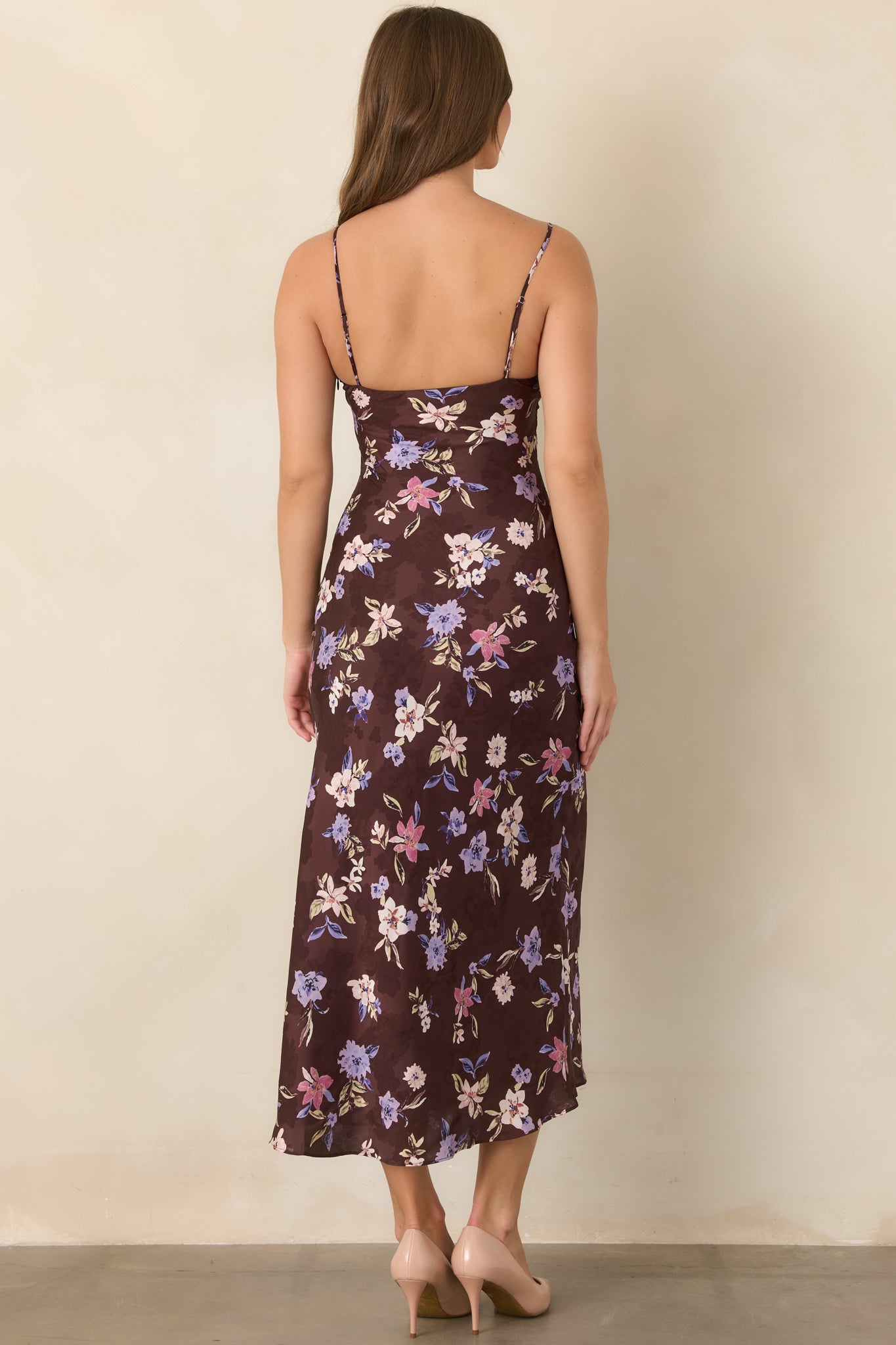 Rear view of the brown floral satin dress showcasing the slender spaghetti straps, smooth fitted bodice, flowing skirt, and concealed side zipper finish.