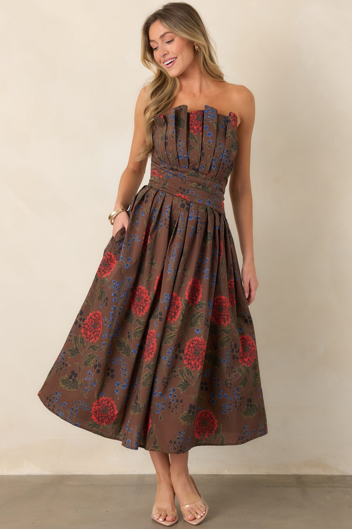 Brown floral strapless midi dress with a pleated bodice, fitted waist and full pleated skirt.