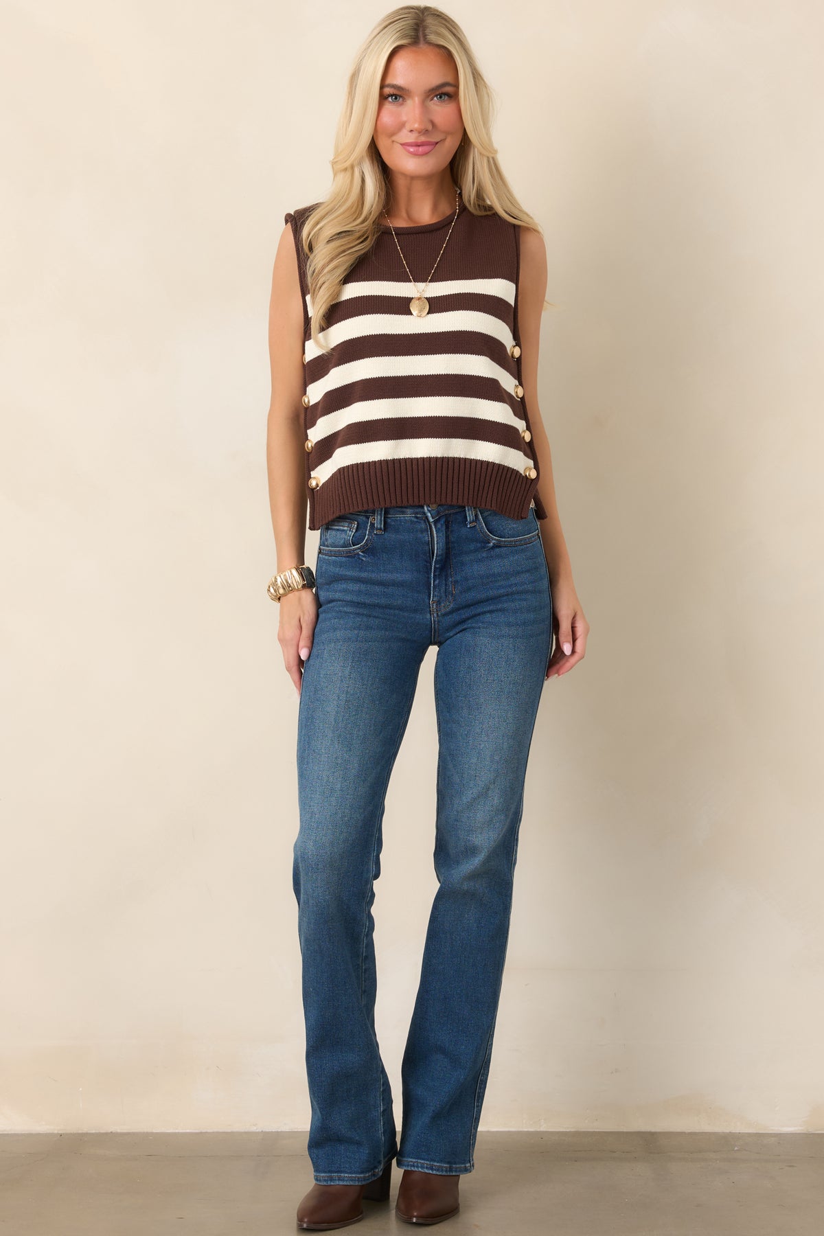 Warm-toned striped top featuring alternating brown and ivory bands, a classic round neckline, relaxed fit, and polished gold-tone buttons along the sides.