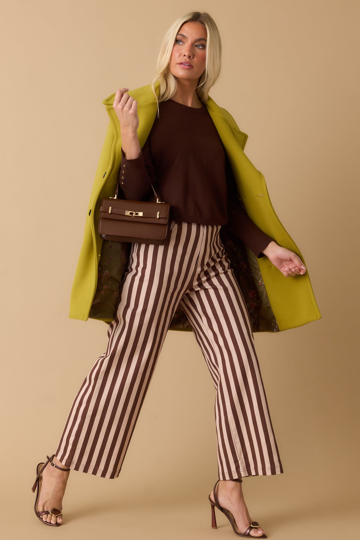 Brown and ivory vertical stripe pants featuring a high-rise waist and cropped wide-leg silhouette with a structured fit.
