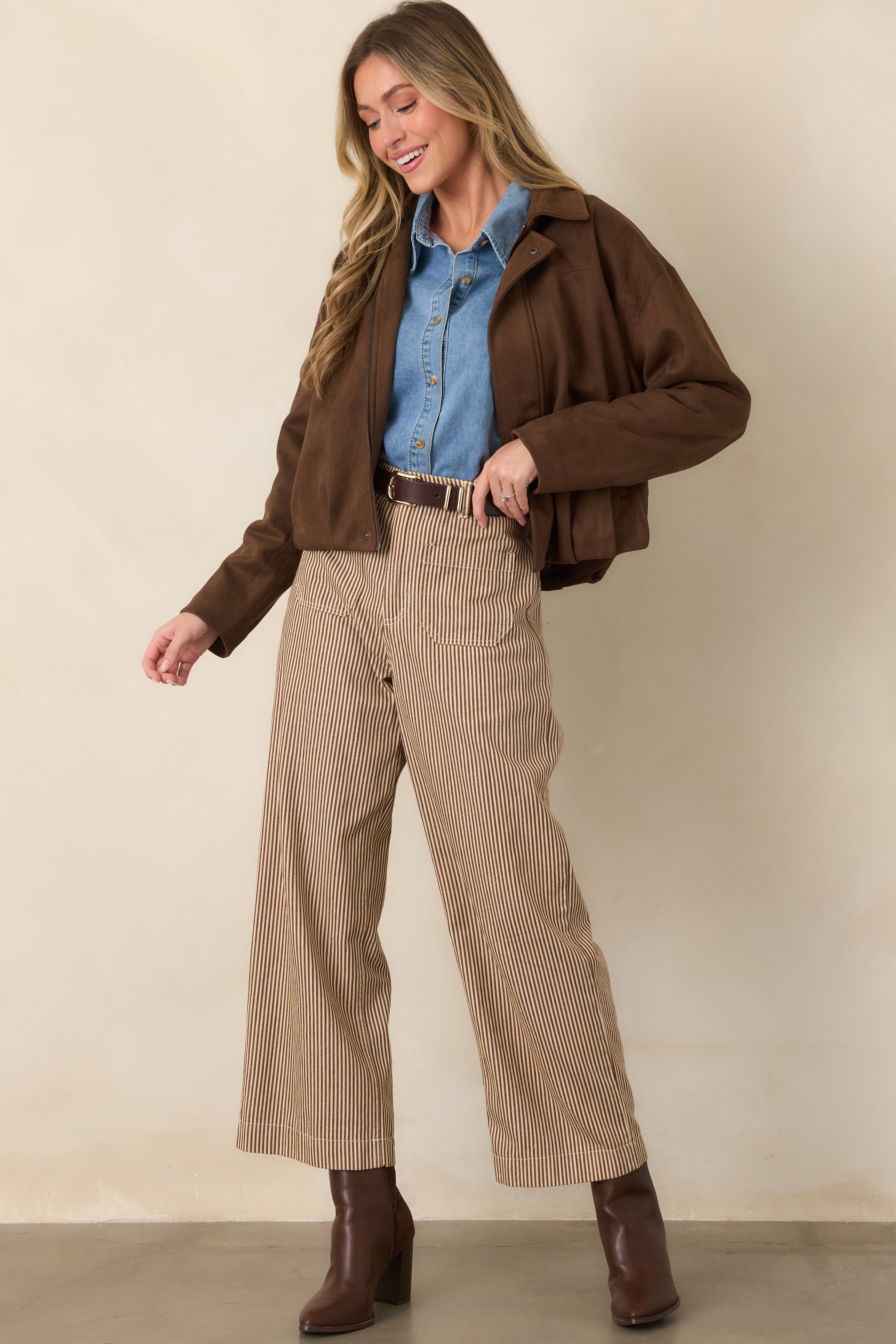 Brown and ivory vertical striped pants with a high-rise fit, functional front pockets, and a comfortable wide-leg silhouette ending at a cropped length.