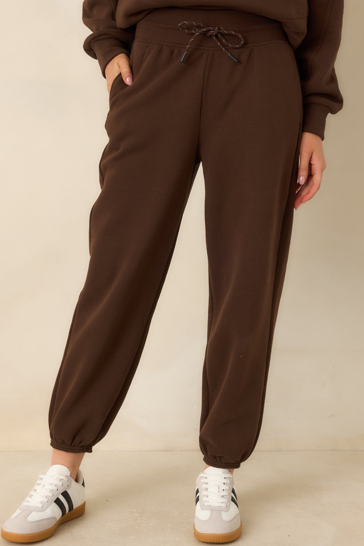 High-rise brown joggers with a ribbed waistband and adjustable drawstring closure.