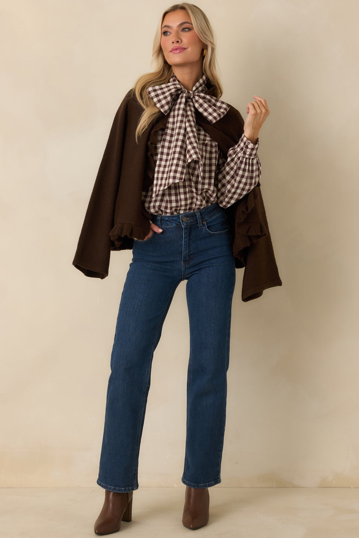 Brown knit cape-inspired cardigan with wide long sleeves and ruffle trim along the open front and hem.