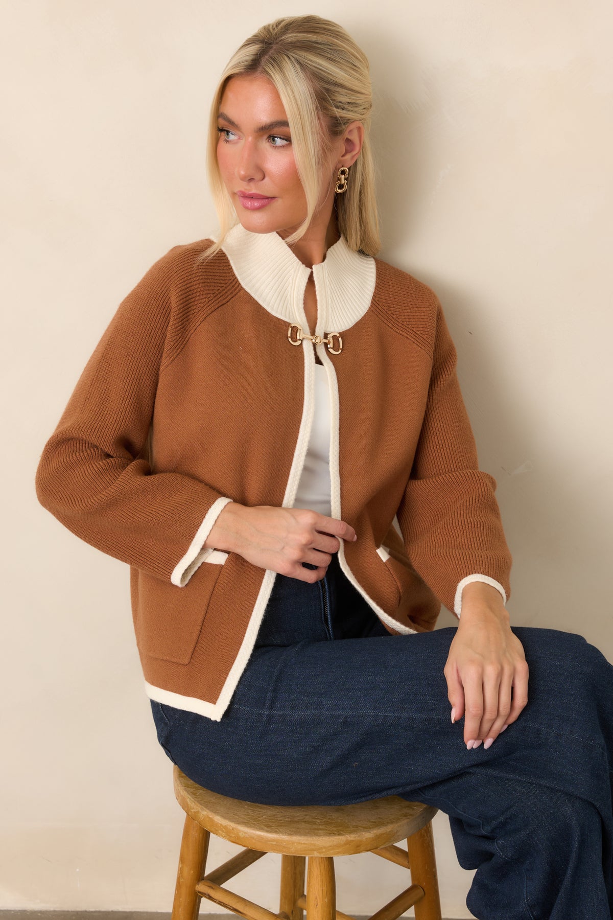 Brown knit cardigan highlighting the gold-tone horsebit closure and ivory-trimmed open front.