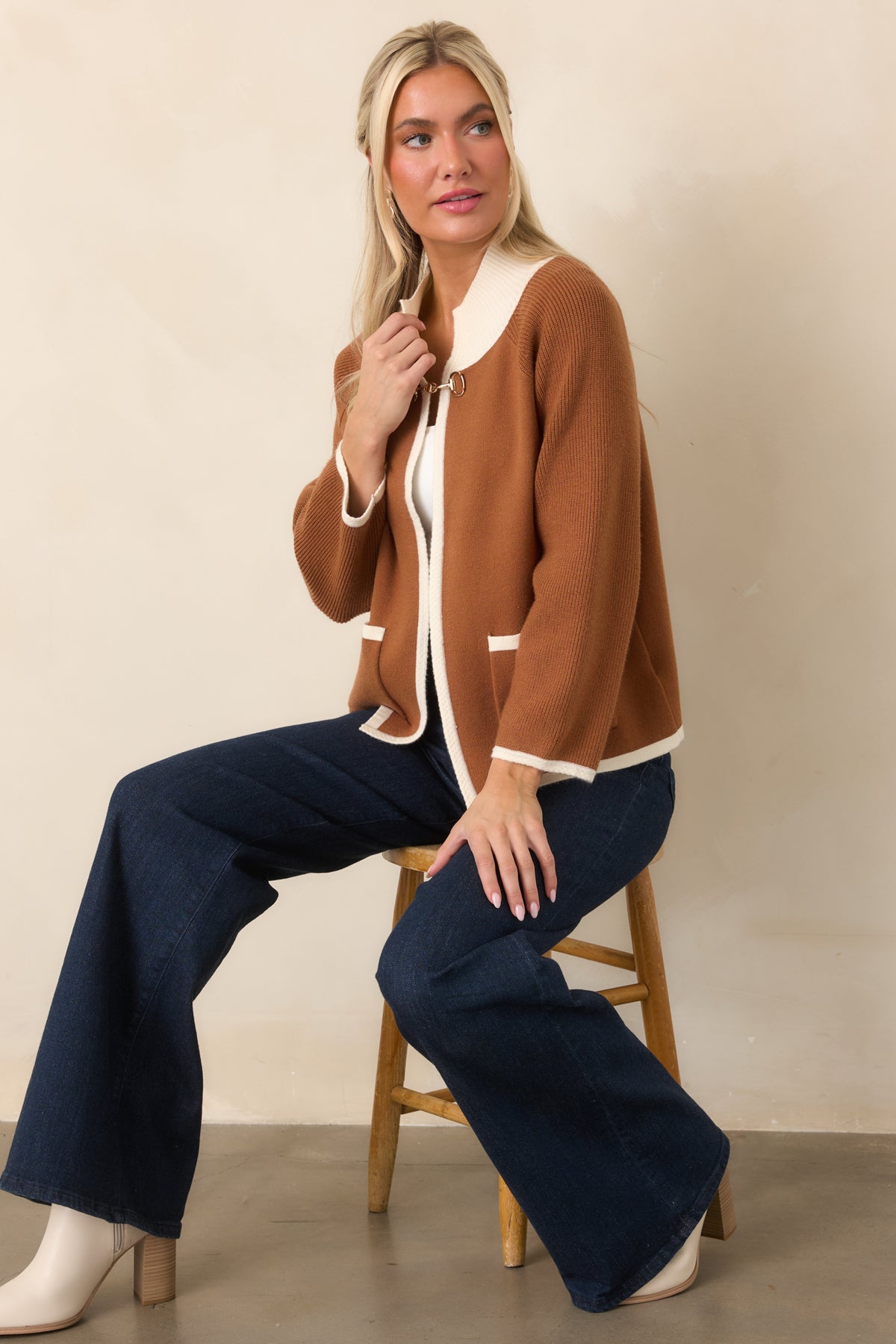 Rich brown knit cardigan with ivory contrast trim, patch pockets, and a gold-tone horsebit closure.