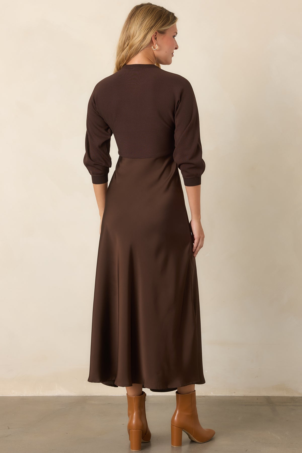 Rear of the brown knit and satin midi dress showing the fitted bodice, three-quarter sleeves, defined waist, and flowing A-line skirt.