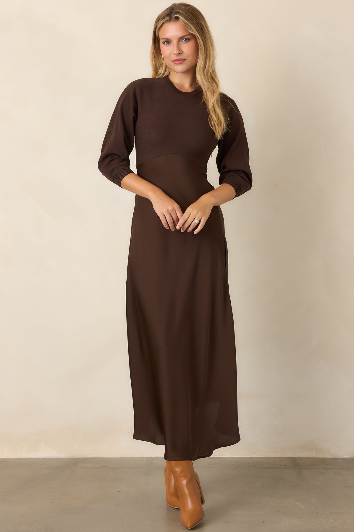 Brown knit and satin midi dress featuring a polished round neckline, three-quarter sleeves, fitted bodice, and softly draped skirt.