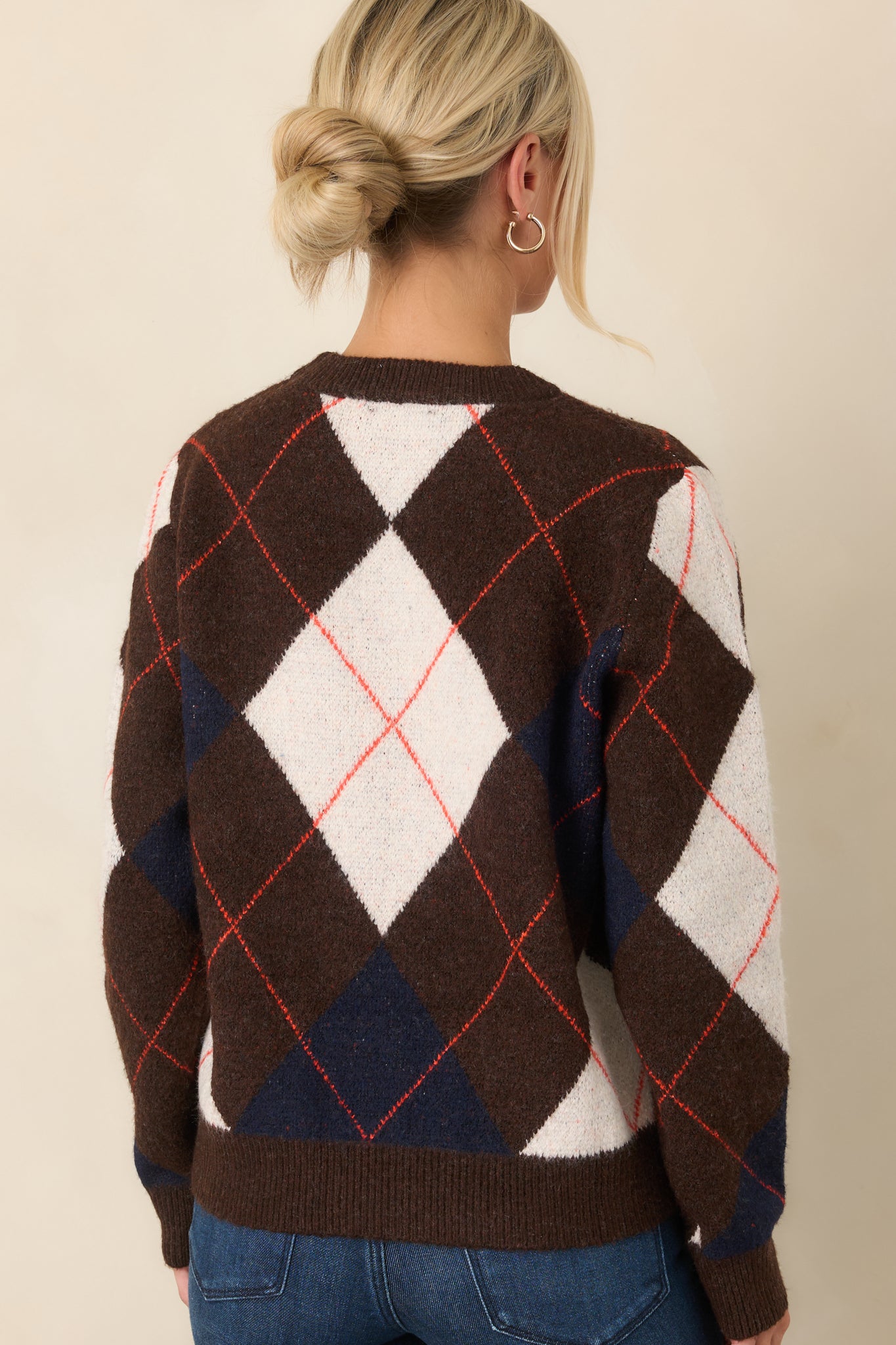 Rear view of the brown knit top showcasing the geometric pattern, long sleeves, and ribbed hem.