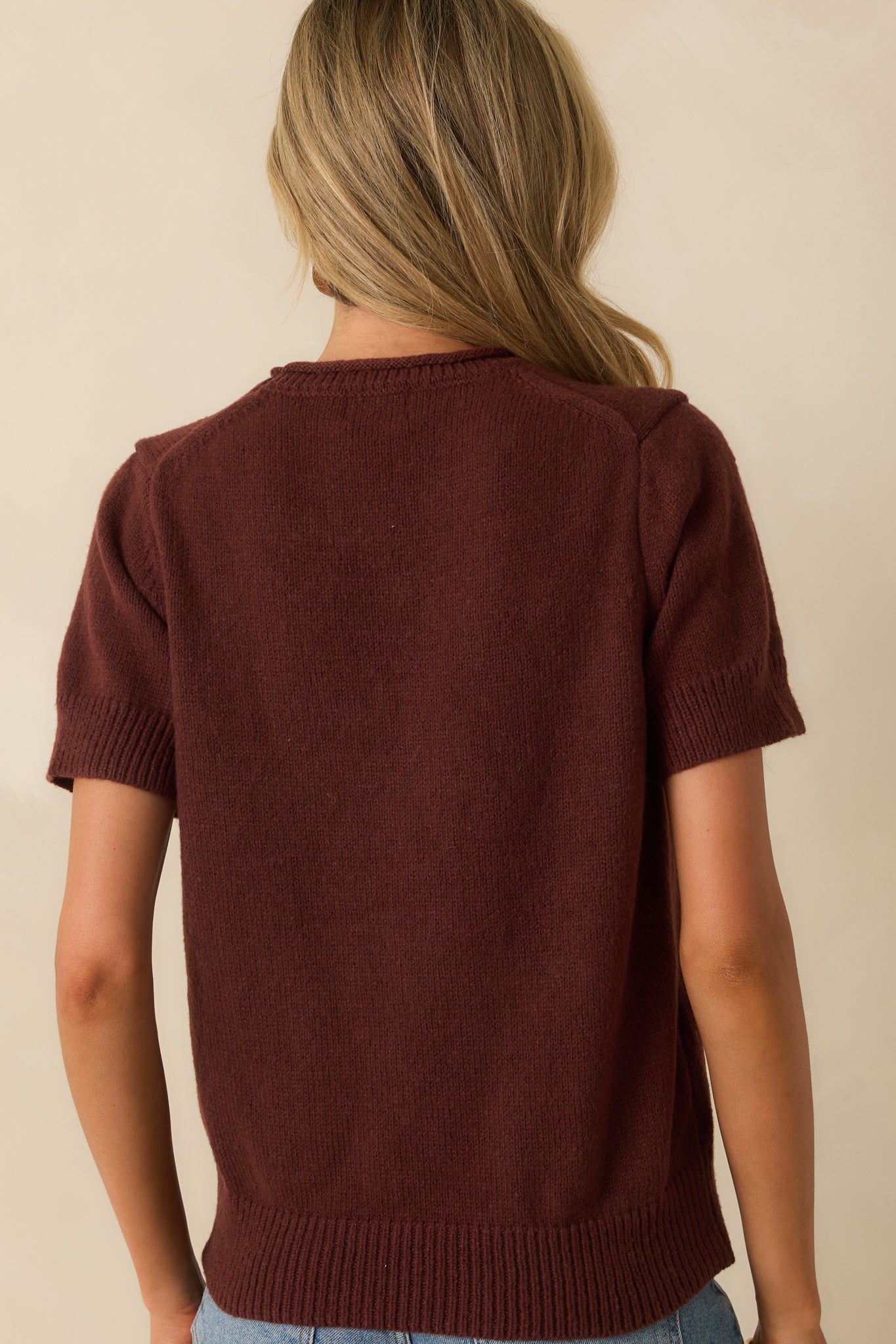 Rear view of the brown knit top showing short sleeves and relaxed fit.