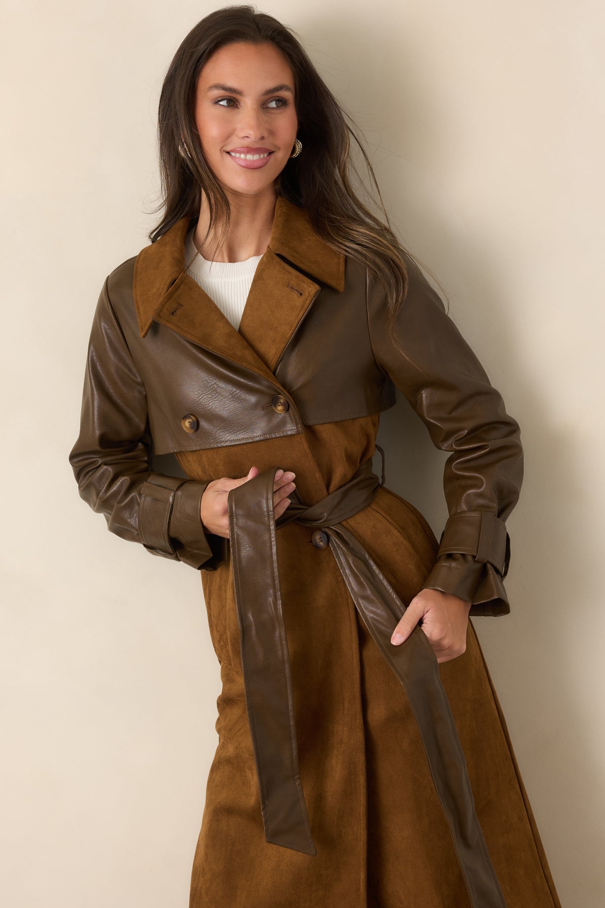 Button-tab cuffs finish the brown faux leather sleeves with a tailored detail that complements the trench styling.