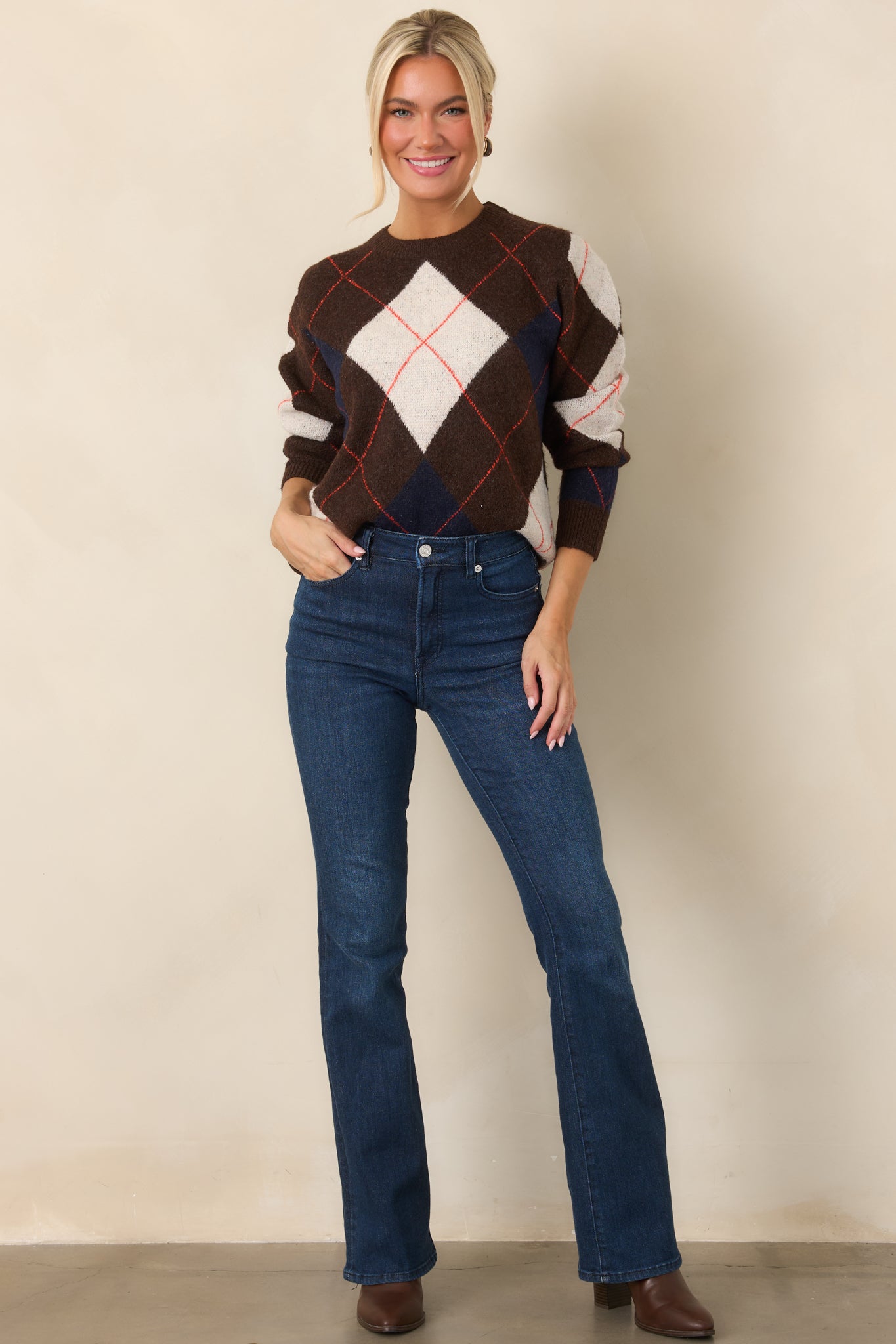 Long-sleeve brown knit top with diamond motifs, subtle rust-red striping, and a comfortable relaxed fit.