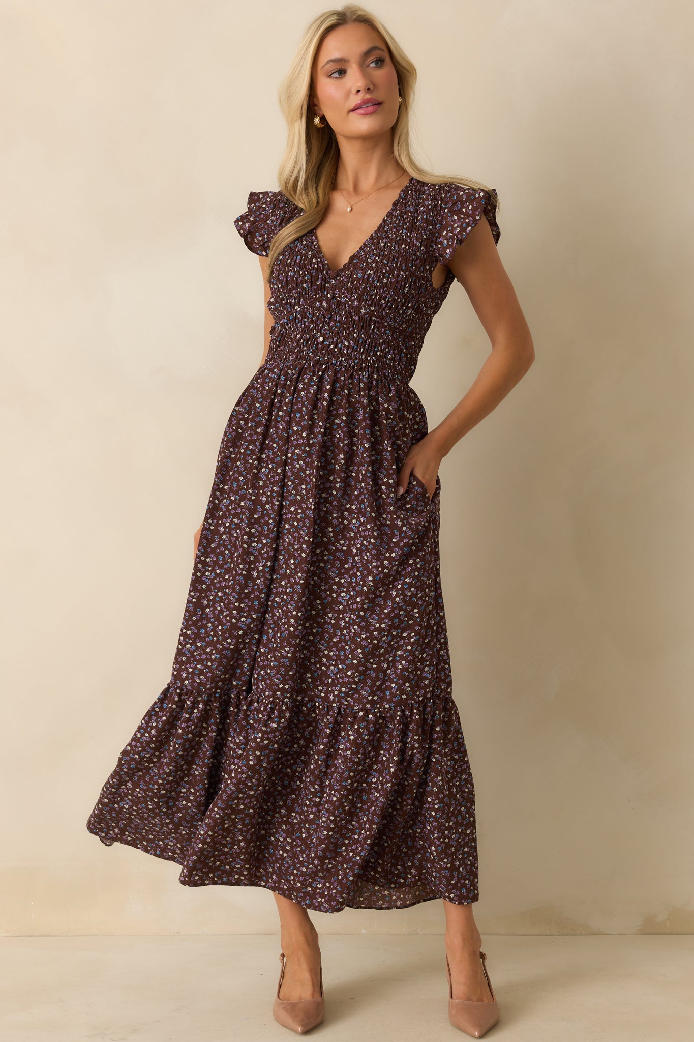 Flowing maxi dress in rich brown with a faux button front, short flutter sleeves, and structured piping details.