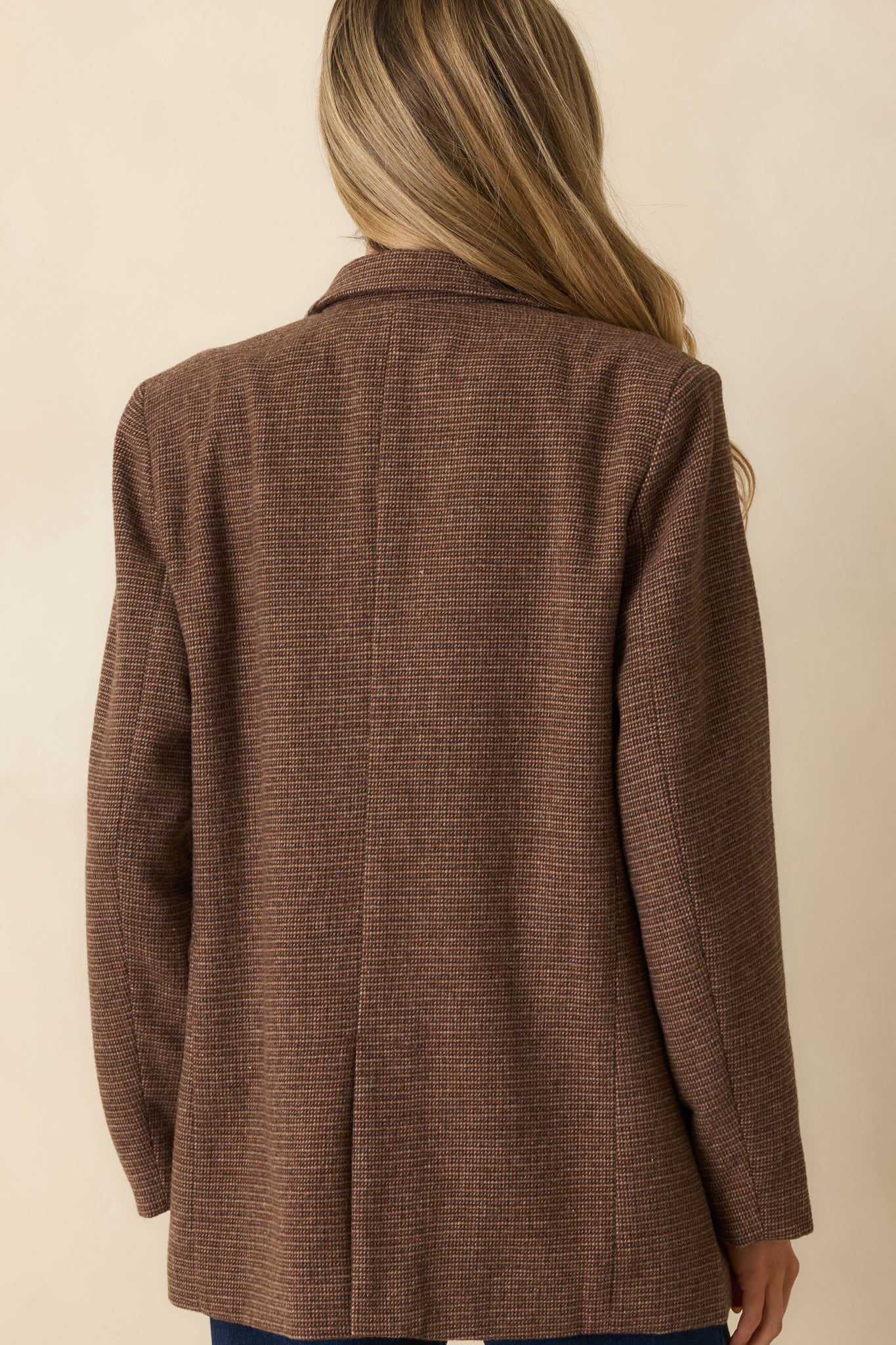 Rear view of the brown micro-houndstooth blazer with vented hem and longline silhouette.