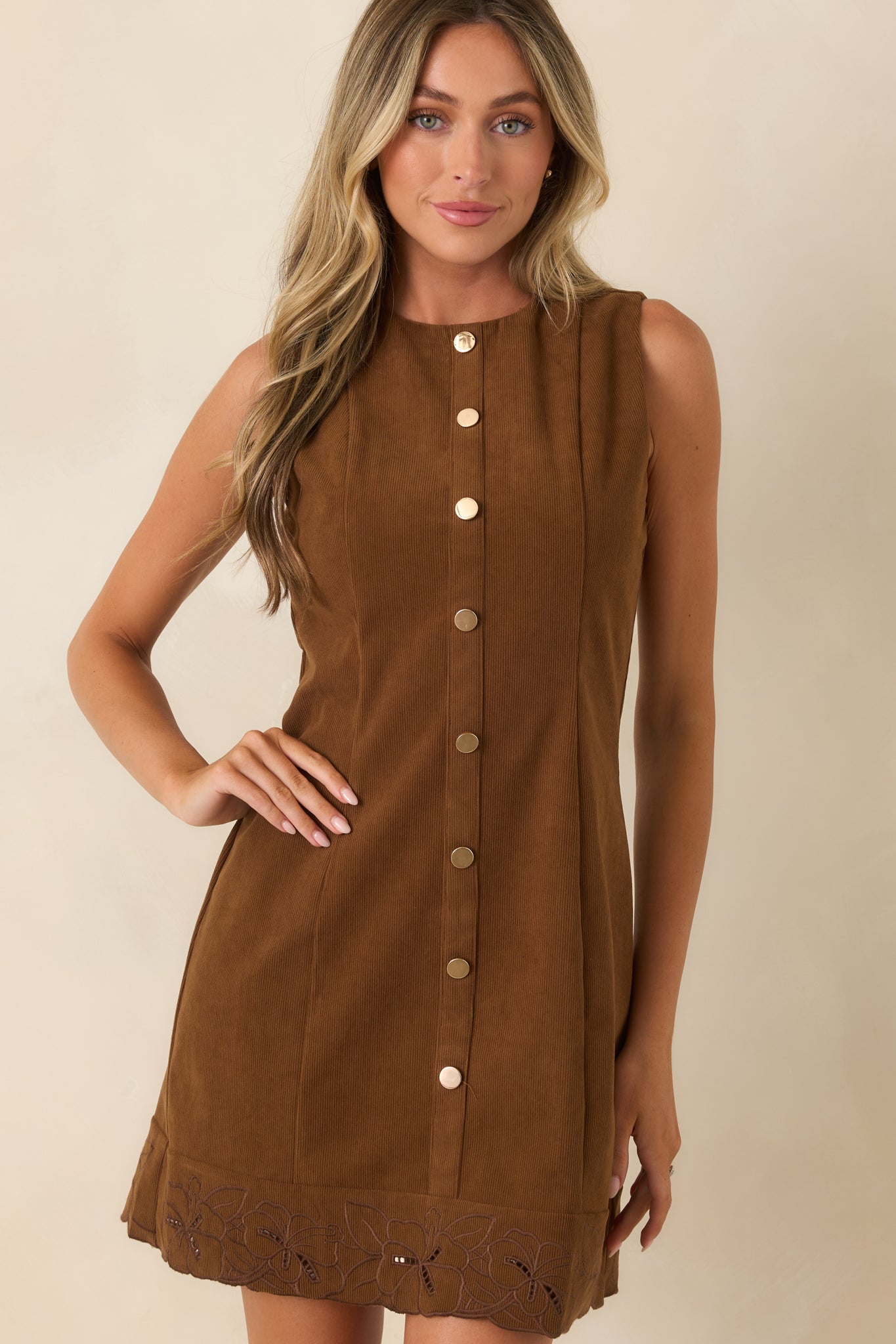 Brown mini dress showcasing floral embroidery, scalloped cutout hem detailing, and rich corduroy texture.