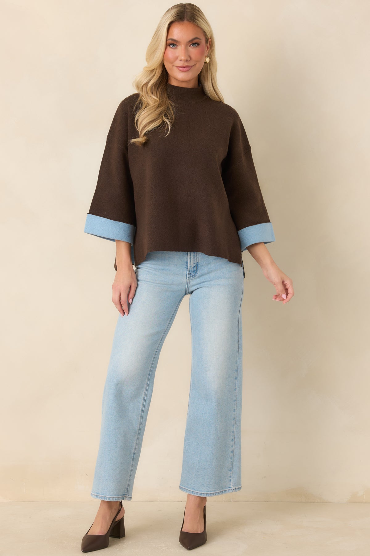 Brown knit top with a polished mock neck, roomy sleeves, and side slits along the hem.