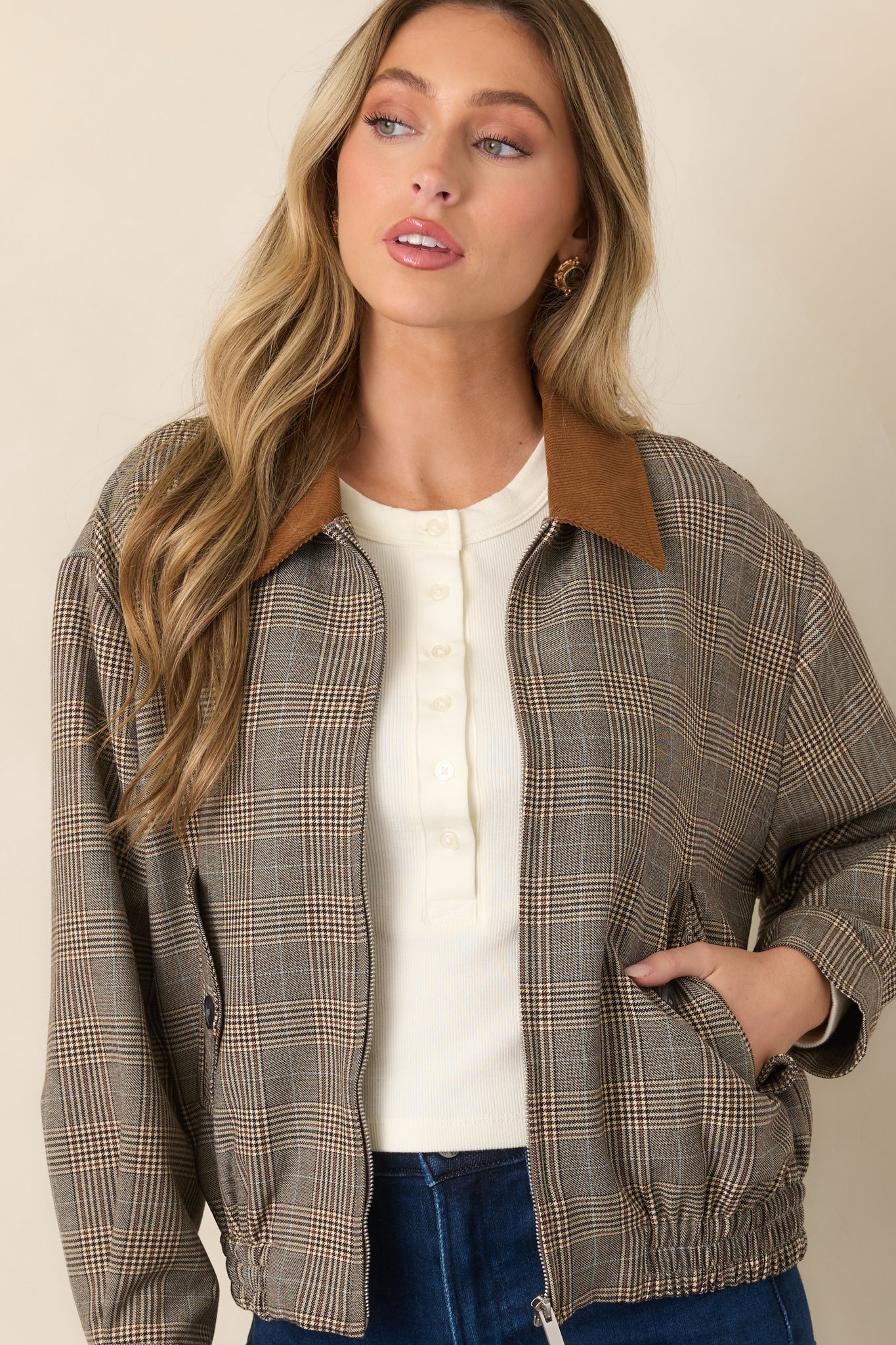 Brown multi-plaid bomber showcasing its buttoned flap chest pockets and varied woven plaid pattern.