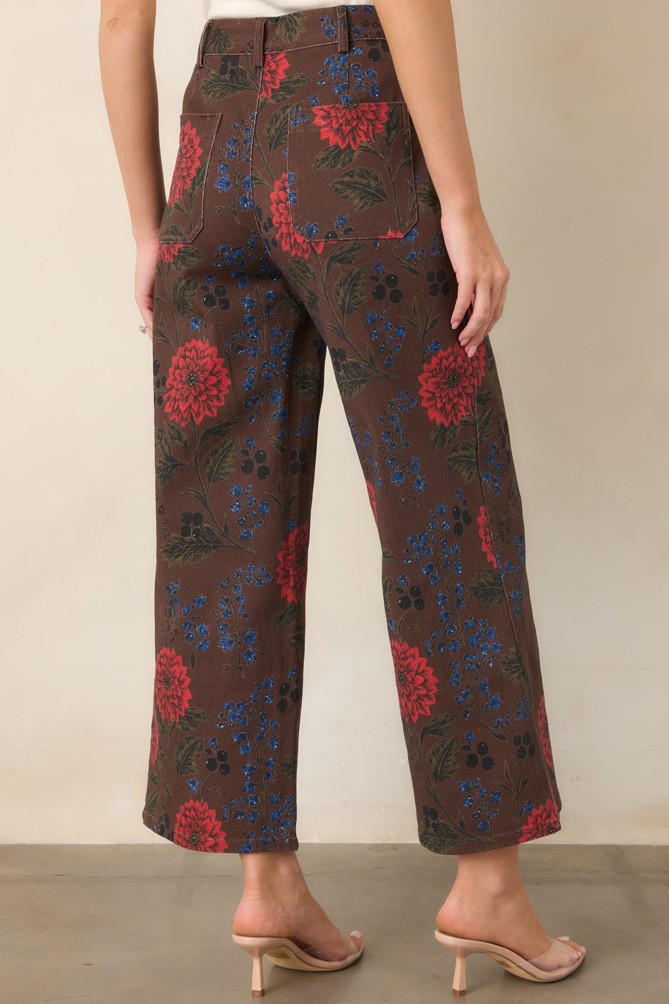 Rear view of the brown cropped pants showcasing oversized back patch pockets, high-rise construction, and wide-leg shape.