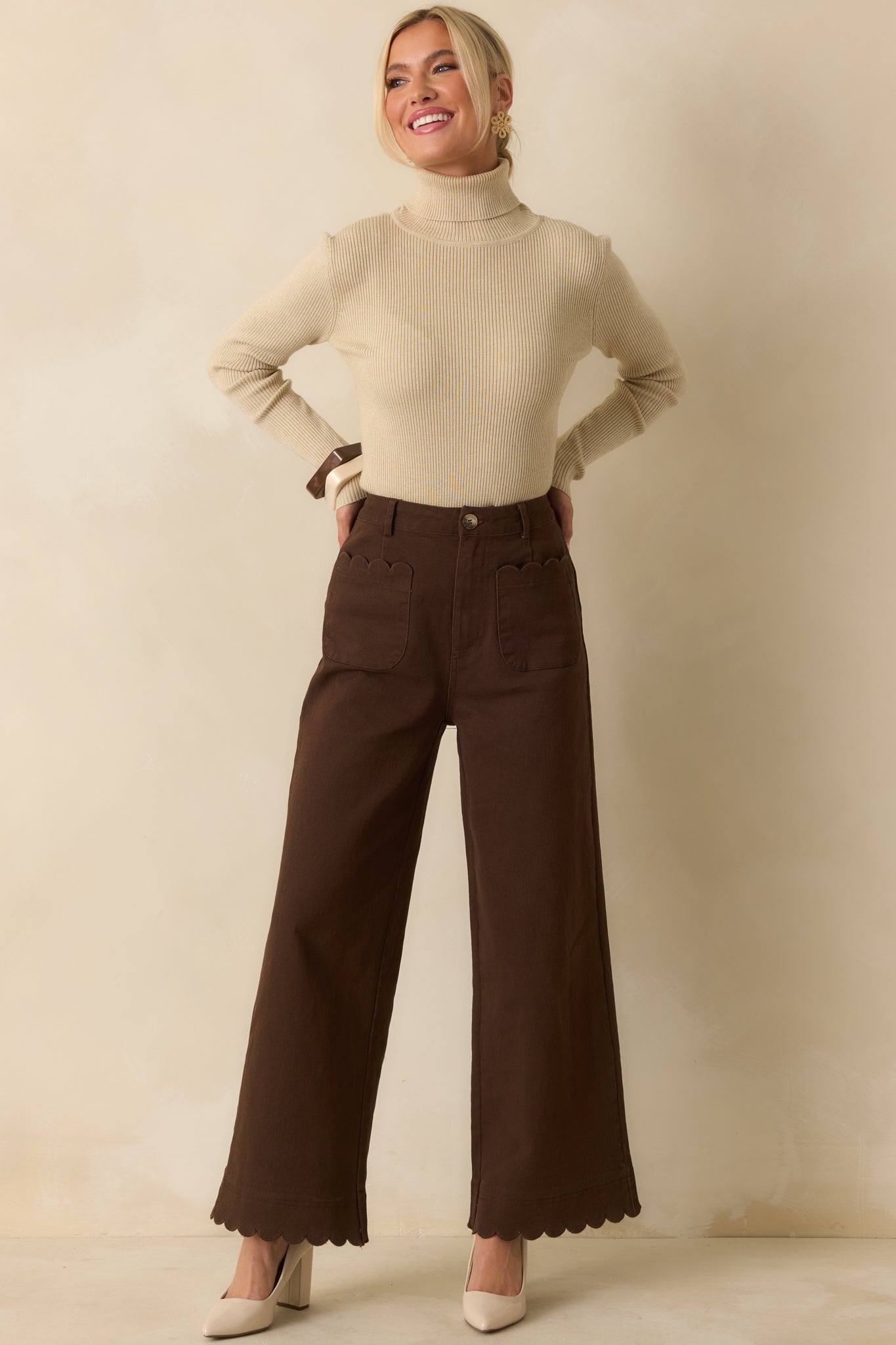 Brown pants with wide-leg silhouette, high-rise fit, and subtle scalloped details at pockets and hem.