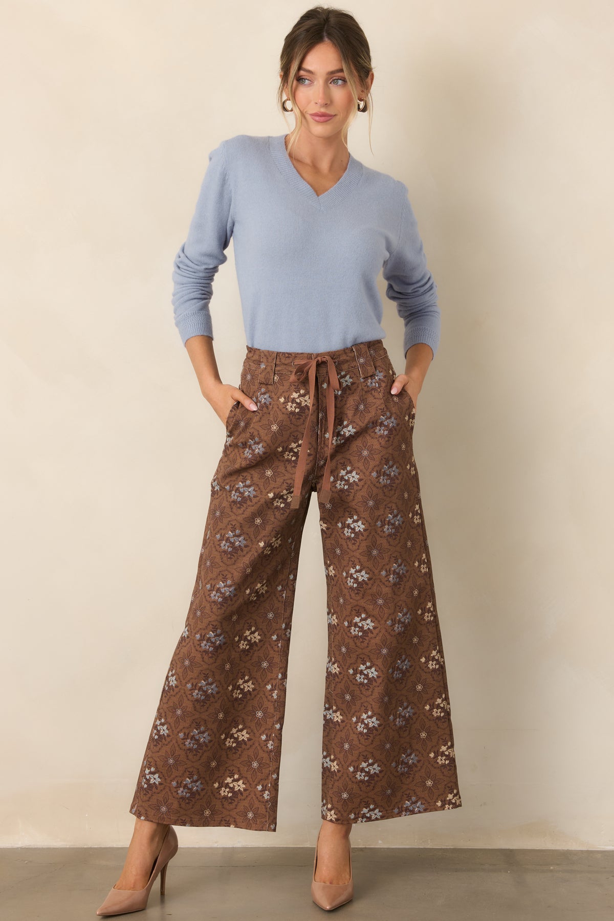 Warm brown patterned pants featuring a relaxed cropped silhouette, side pockets, and a structured waistband.