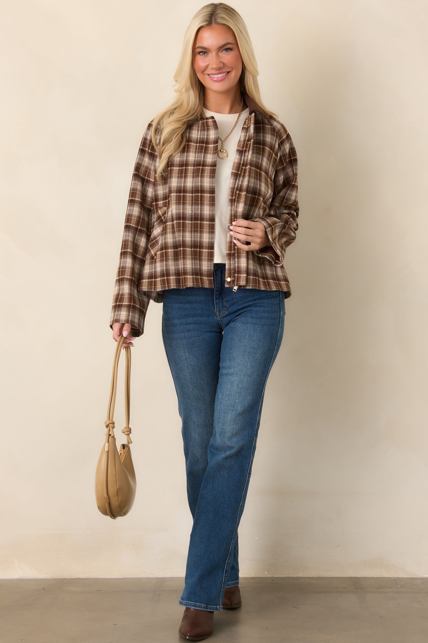 Relaxed brown plaid jacket featuring a hidden snap at the collar, full zip closure, long sleeves, and practical side pockets.