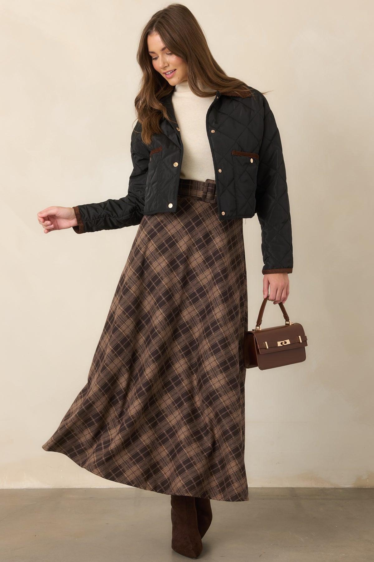 Brown plaid maxi skirt featuring a high-rise waist, optional coordinating belt, and sweeping A-line silhouette.