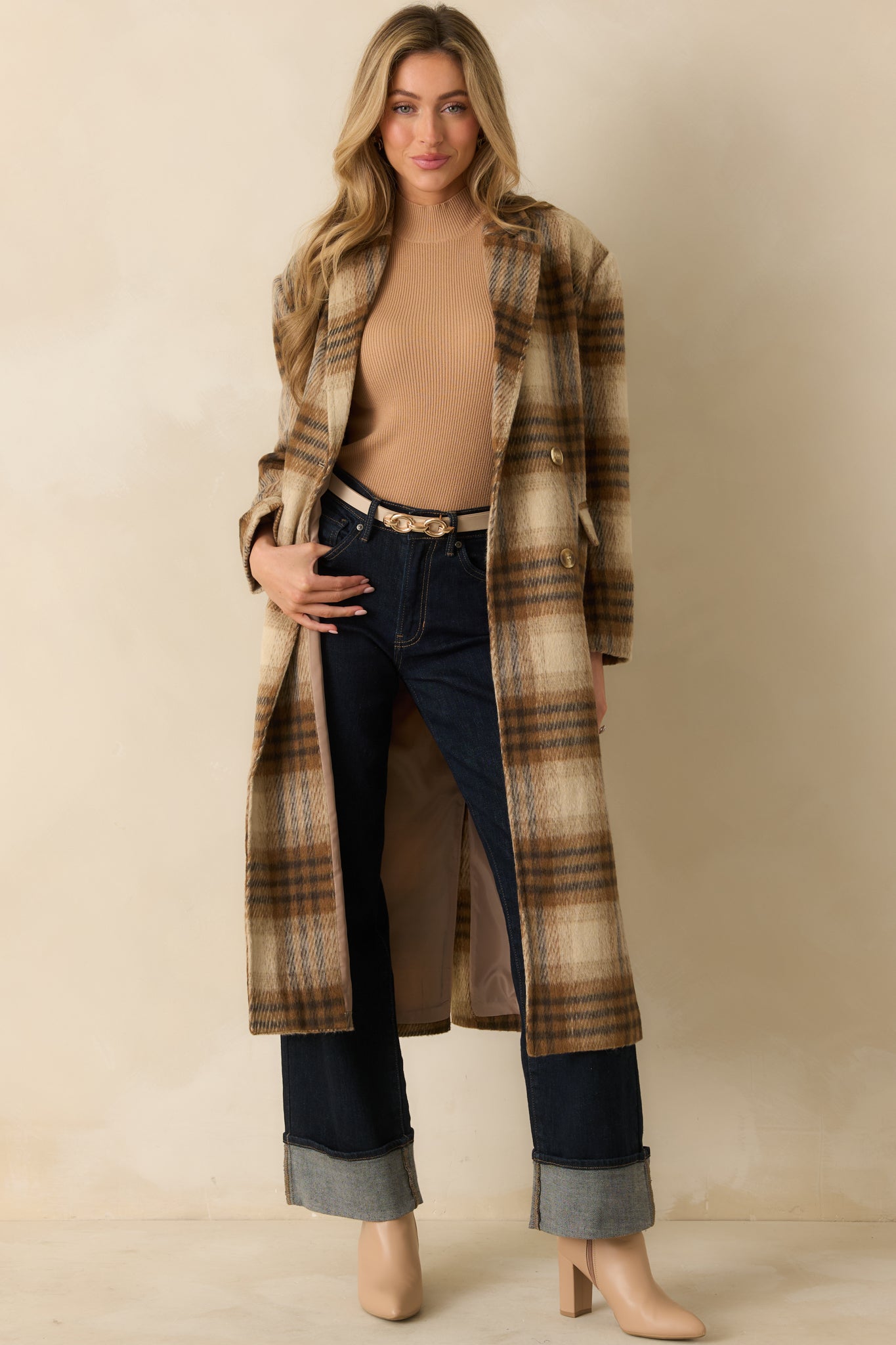 Brown plaid overcoat with notched lapels and a tailored shape, highlighting its structured yet relaxed design.
