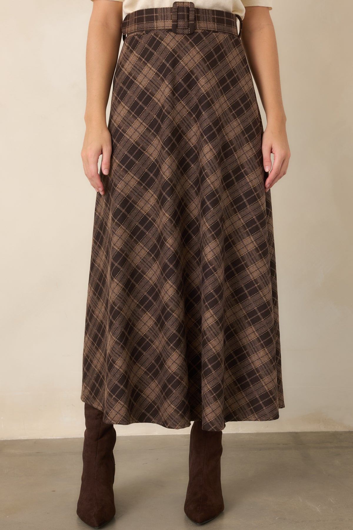 Soft brown plaid skirt featuring a classic neutral pattern and flowing A-line silhouette with movement through the hem.