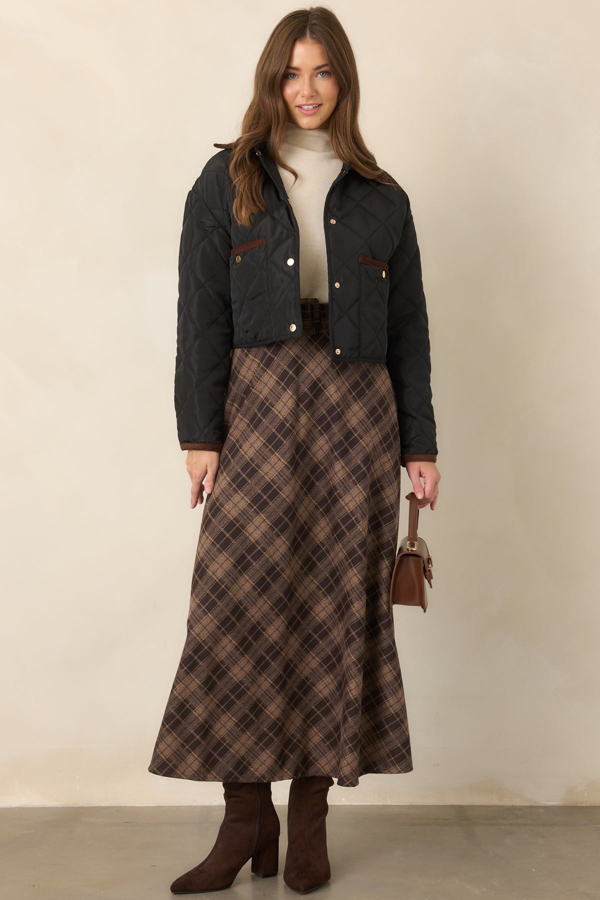 Neutral brown plaid skirt designed with a soft texture, high-rise waist, and flowing A-line shape through the hem.