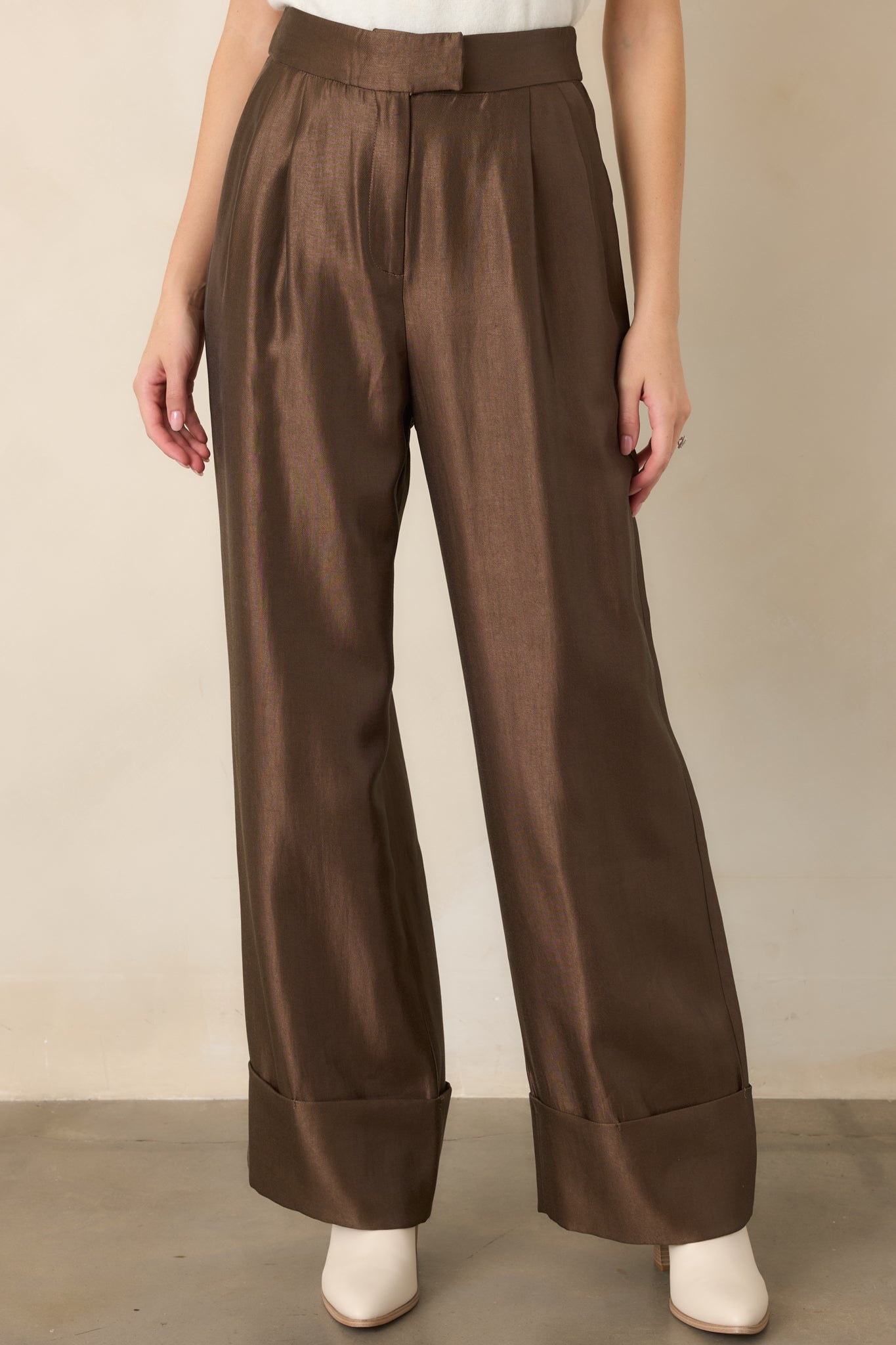 Detailed view of the wide-leg pants showcasing the front pleating, softly lustrous finish, and oversized cuffed hem.