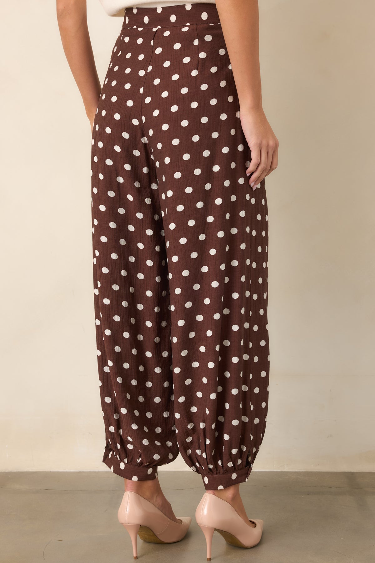 Rear view of the brown polka dot pants showing the high-rise waistband and voluminous balloon legs.