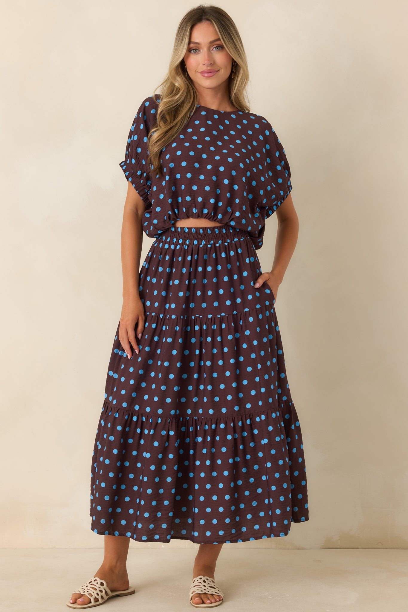 Relaxed brown top with blue polka dots, softly draped sleeves, and a flattering blouson shape.