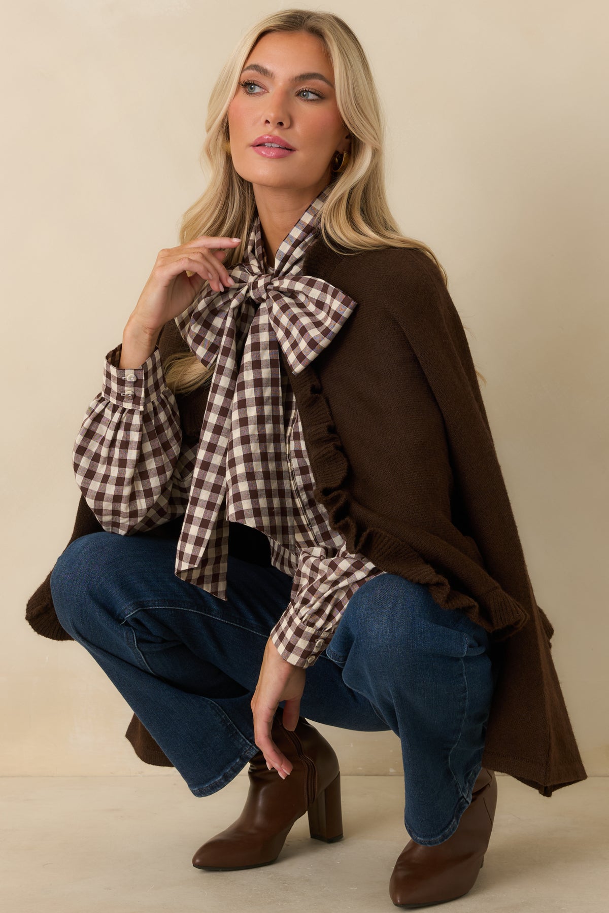Relaxed brown knit cardigan draped over the body with wide sleeves and softly gathered ruffle edging.