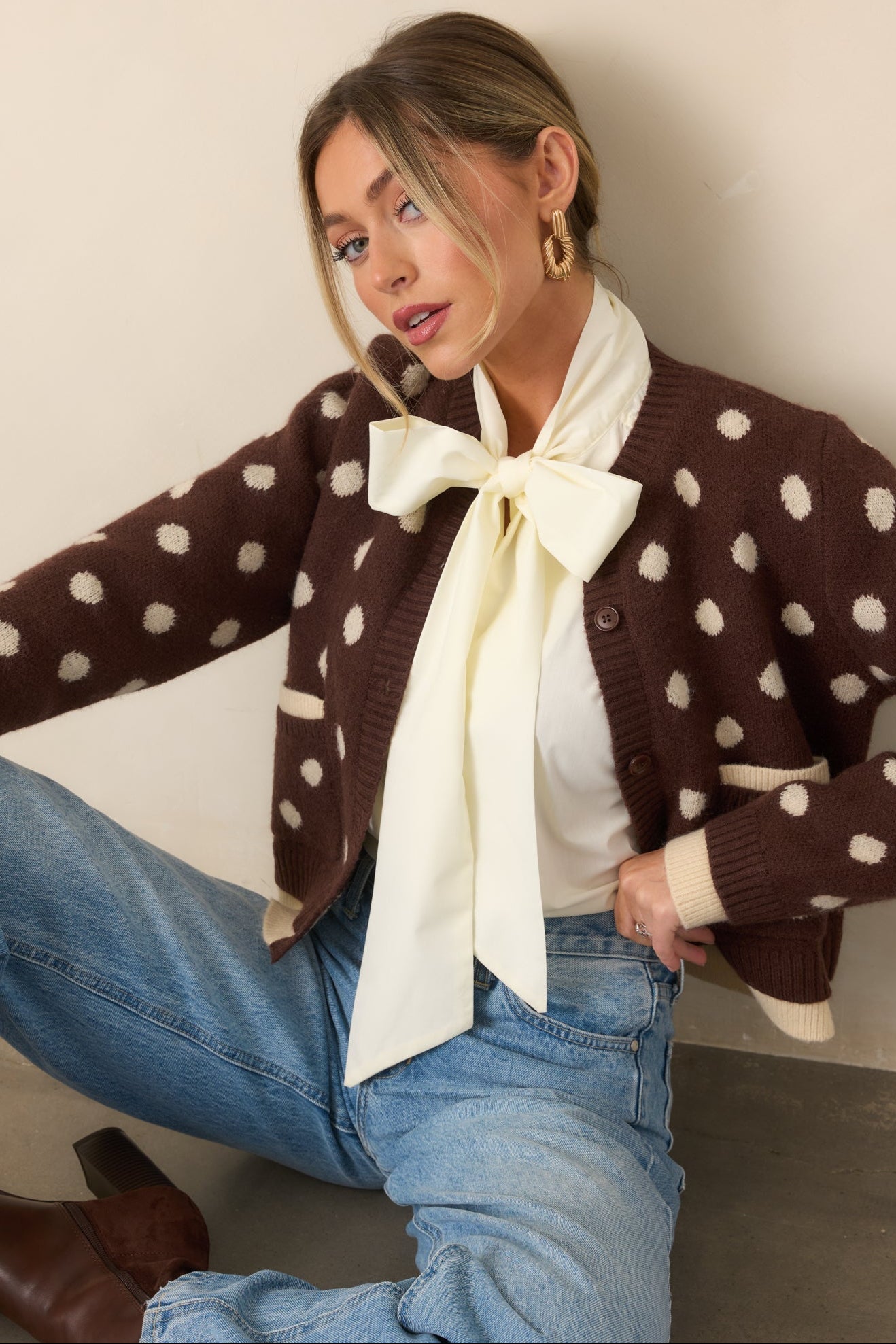 Brown ribbed cardigan showcases dimensional ivory edging beneath the hem and cuffs for a layered finish.
