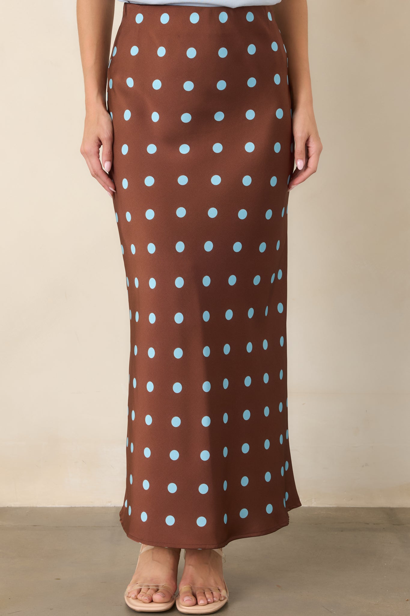 Detailed view of the silky skirt revealing its fluid satin texture and evenly spaced light blue polka dots.