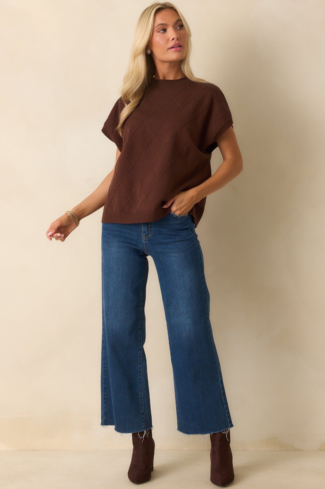 Brown short-sleeve sweater showing relaxed fit, rolled crew neckline, and straight hemline.