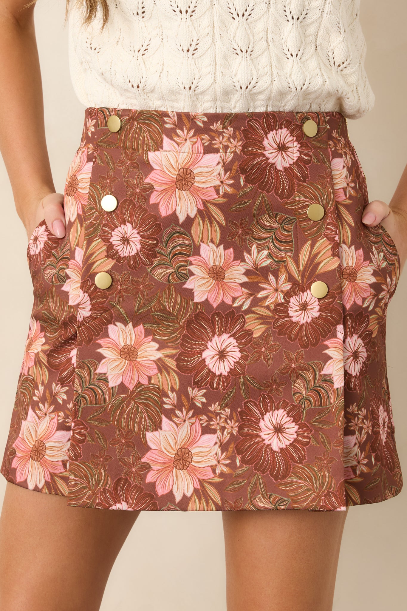 Close-up view of the skirt’s floral pattern, highlighting soft pink and mauve blossoms against the rich brown base.