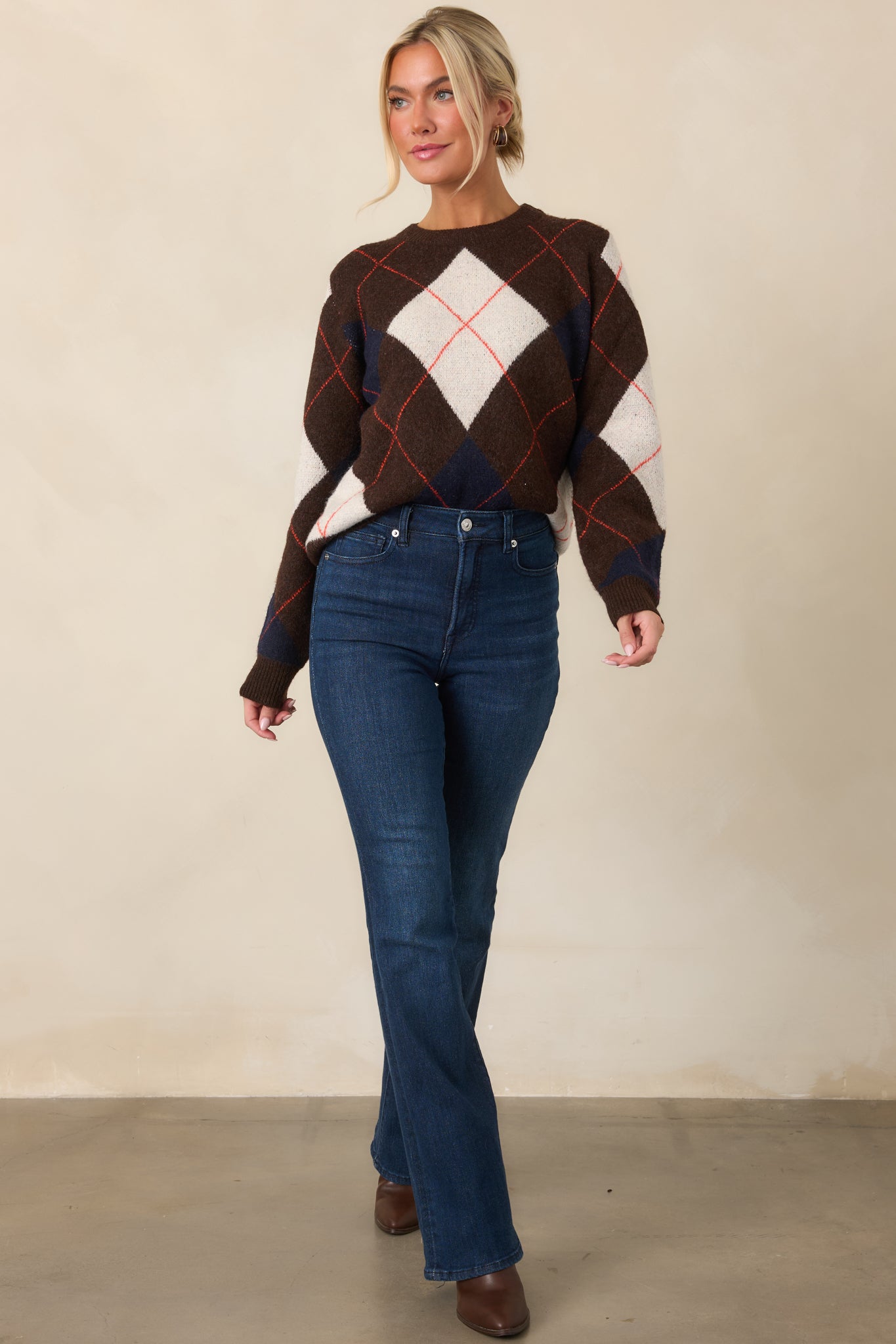 Relaxed-fit brown sweater with geometric diamond accents in ivory and navy, accented by fine rust-red lines throughout.