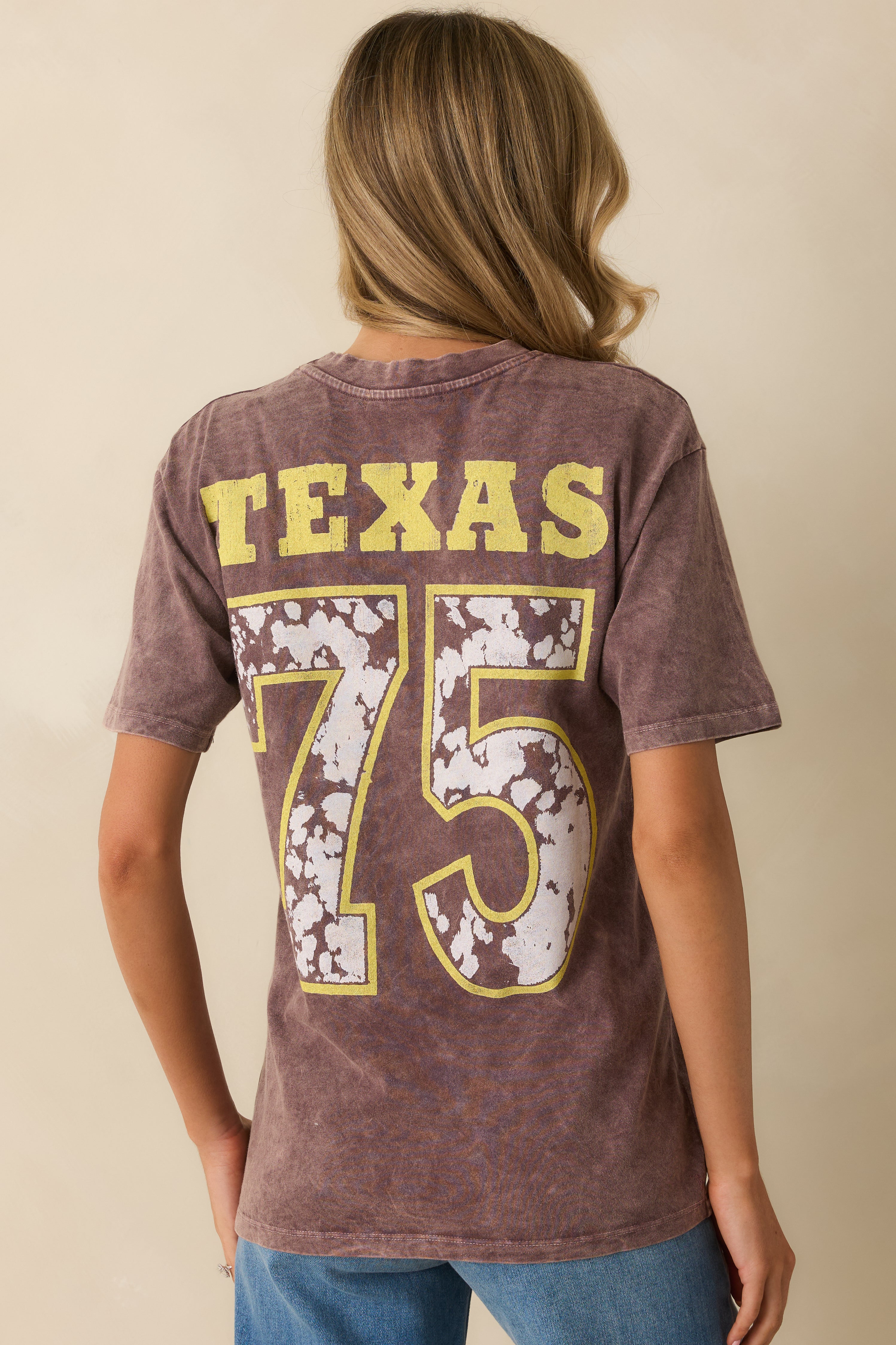Back view of the tee showing the brown back with the yellow and white "Texas 75" graphic.