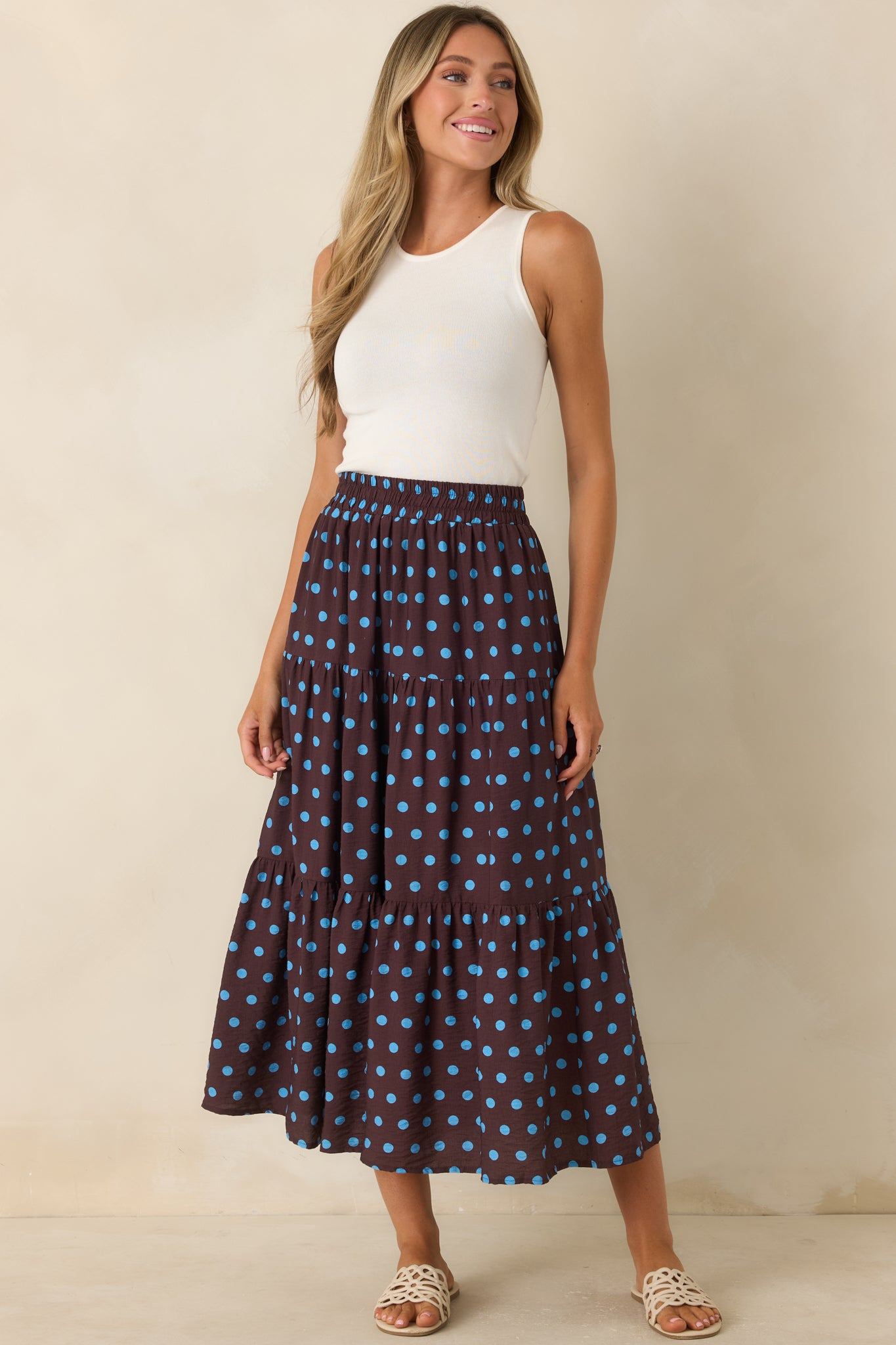 Brown tiered skirt featuring a lightweight draped silhouette, blue polka dot print, smocked waistband, and soft flowing layers.